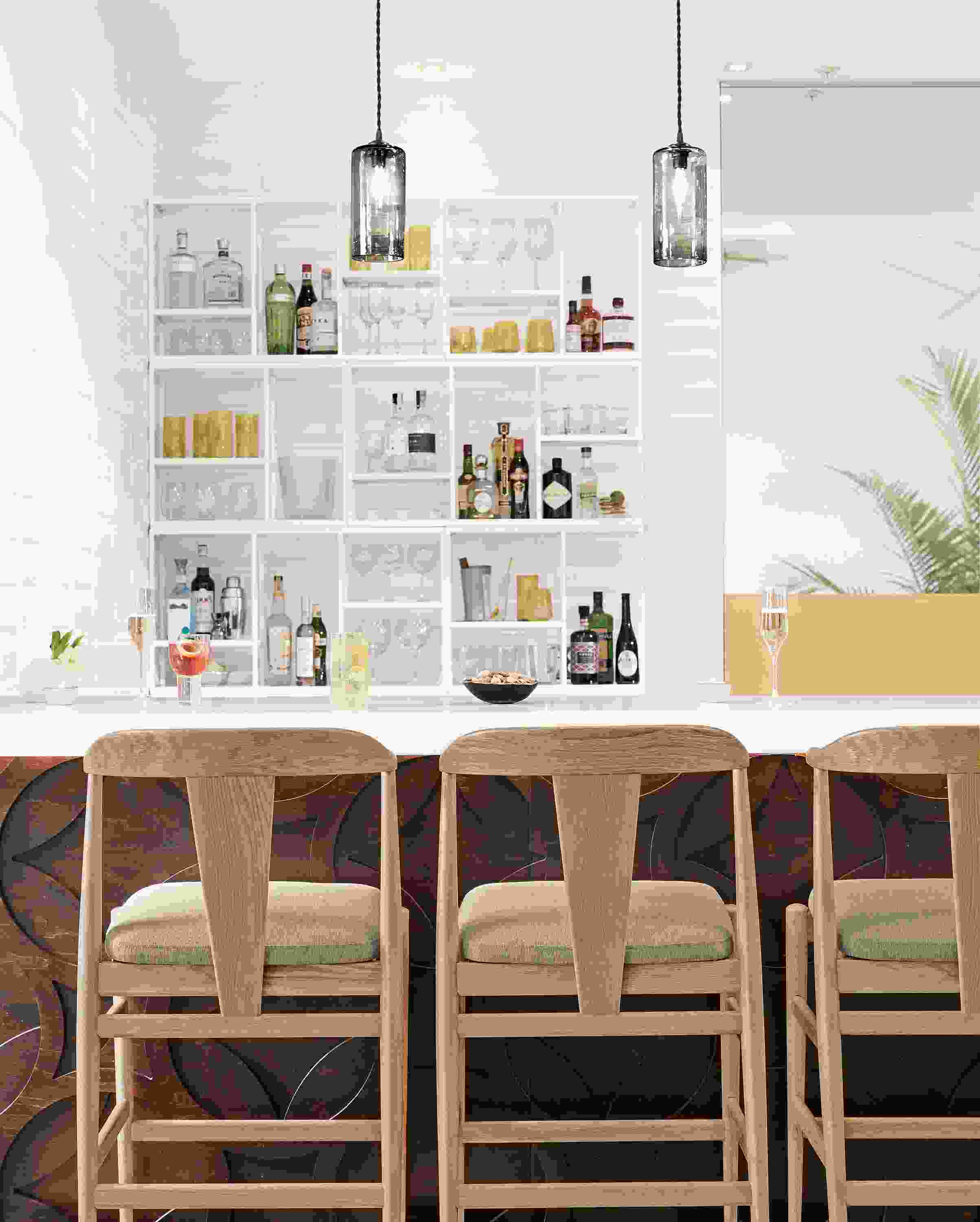 Three Evan counter stools in rye on red oak with flint ivory fabric seats and 2 swift pendant lights in smoke glass.