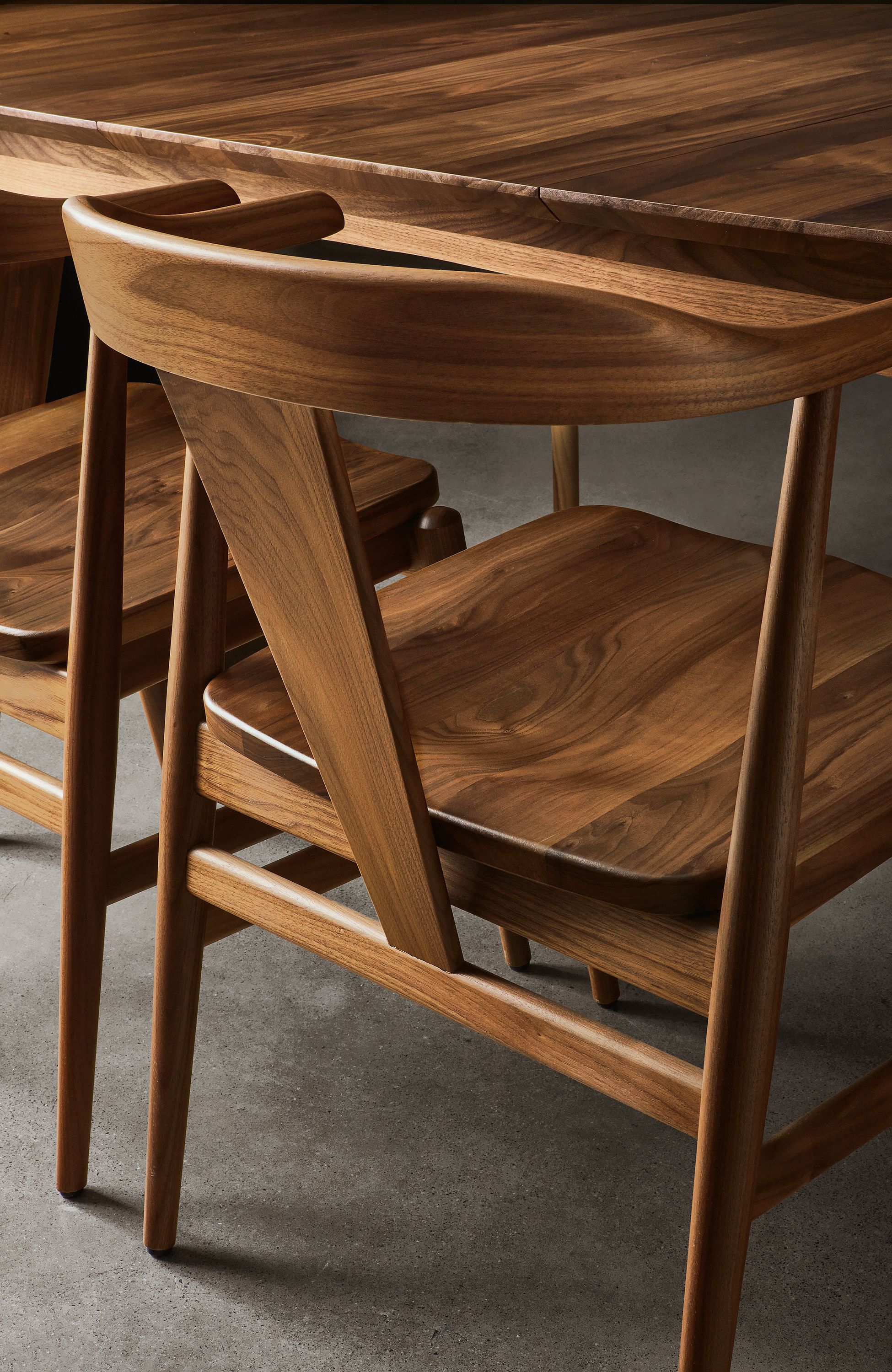 detail of evan arm chair in walnut at walnut table.