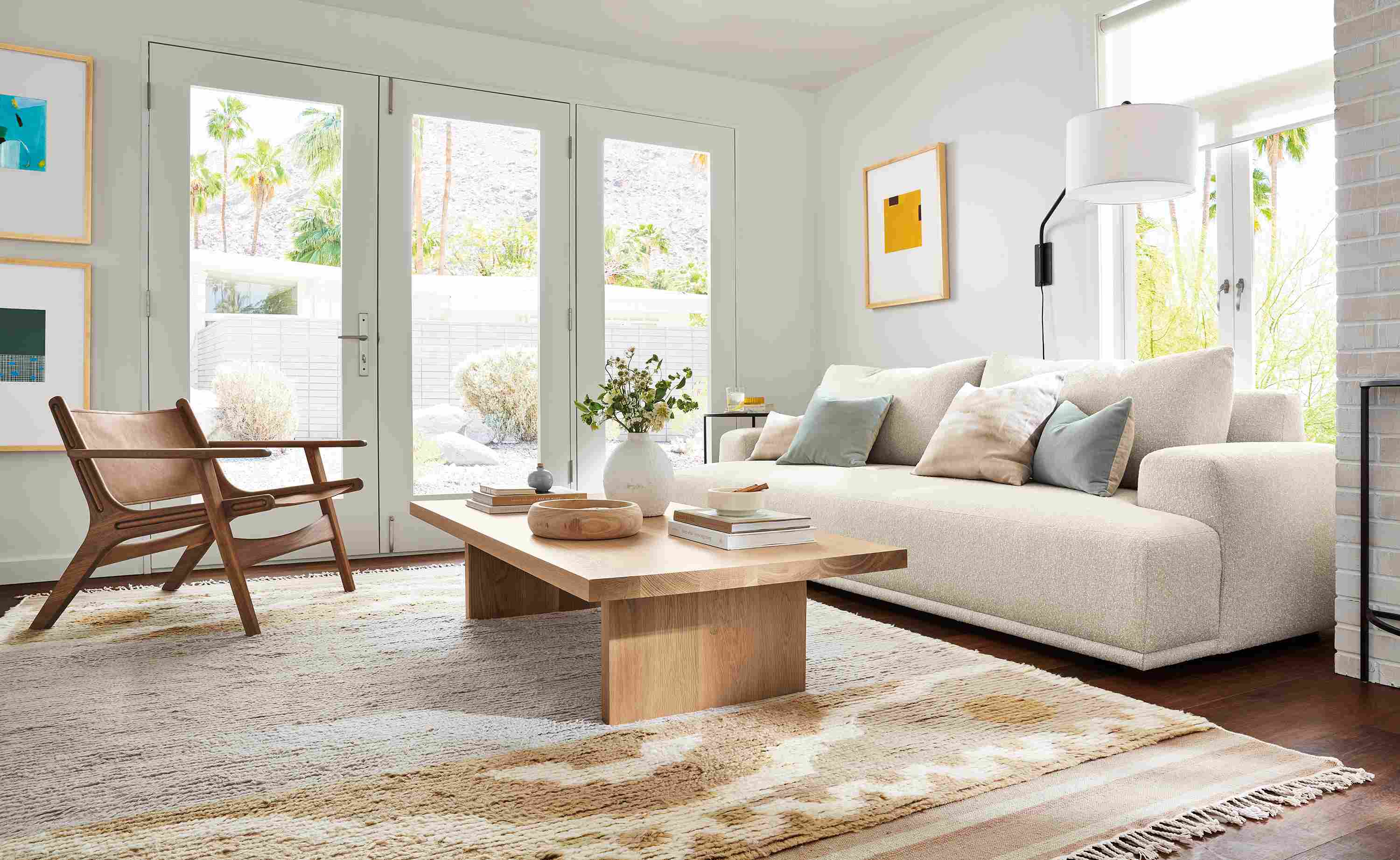 Living room with fia bench cushion sofa in conley natural, corbett coffee table in rye on red oak and tova rug in sand.