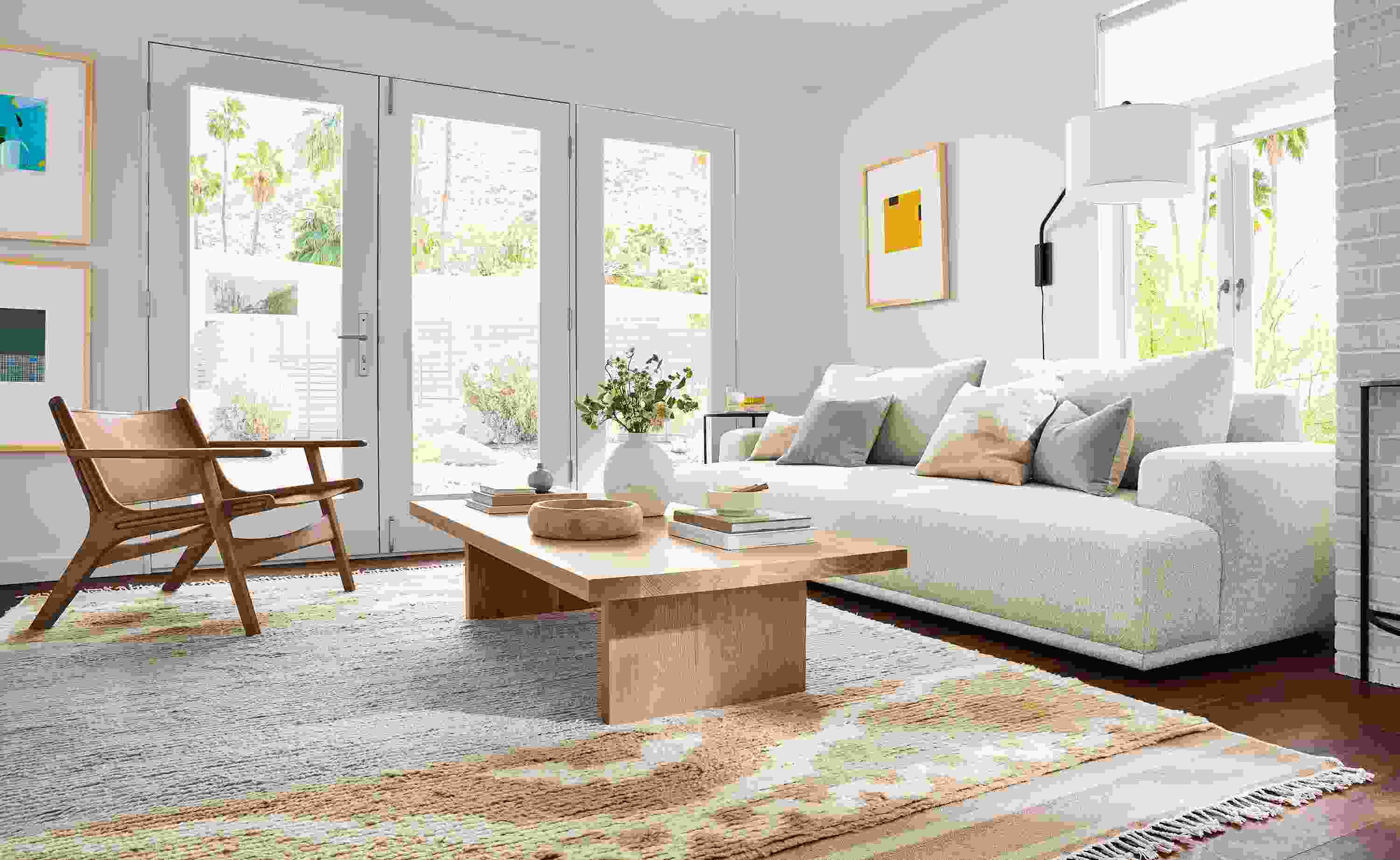Living room with fia bench cushion sofa in conley natural, corbett coffee table in rye on red oak and tova rug in sand.
