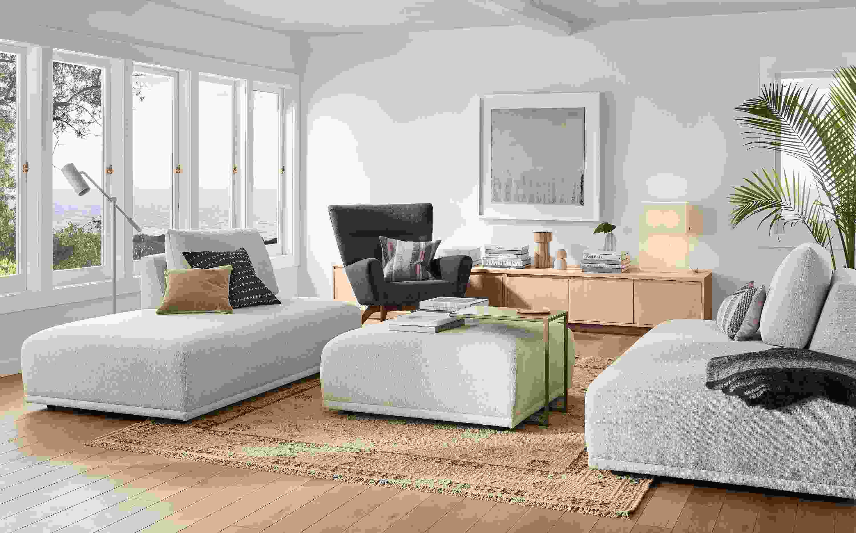 Living room with Fia sofas and ottoman in Conley Natural, Boden chair in Declan Graphite and Keaton media cabinet salt on red oak.