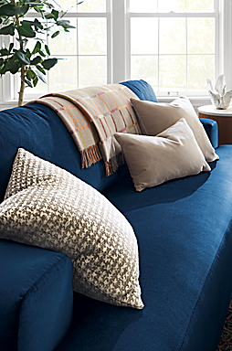 detail of fia sofa in vance indigo with velvet throw pillows, Essex throw blanket.