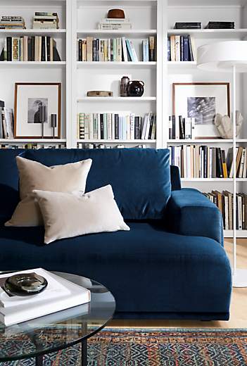 detail of fia sofa in vance indigo with two velvet throw pillows in living room.