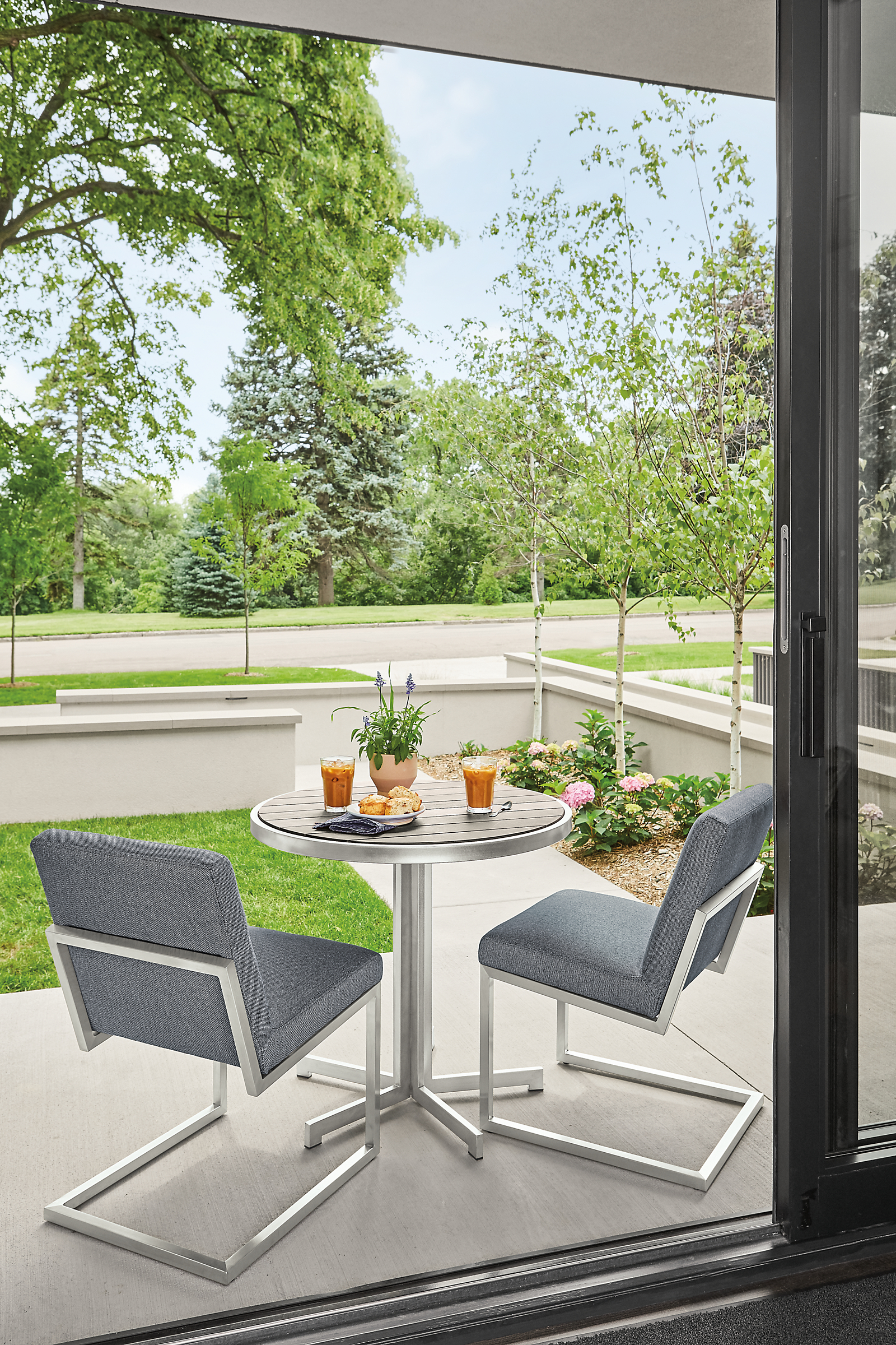 outdoor patio with finn side chairs in mist fabric and montego round table in aged ash.