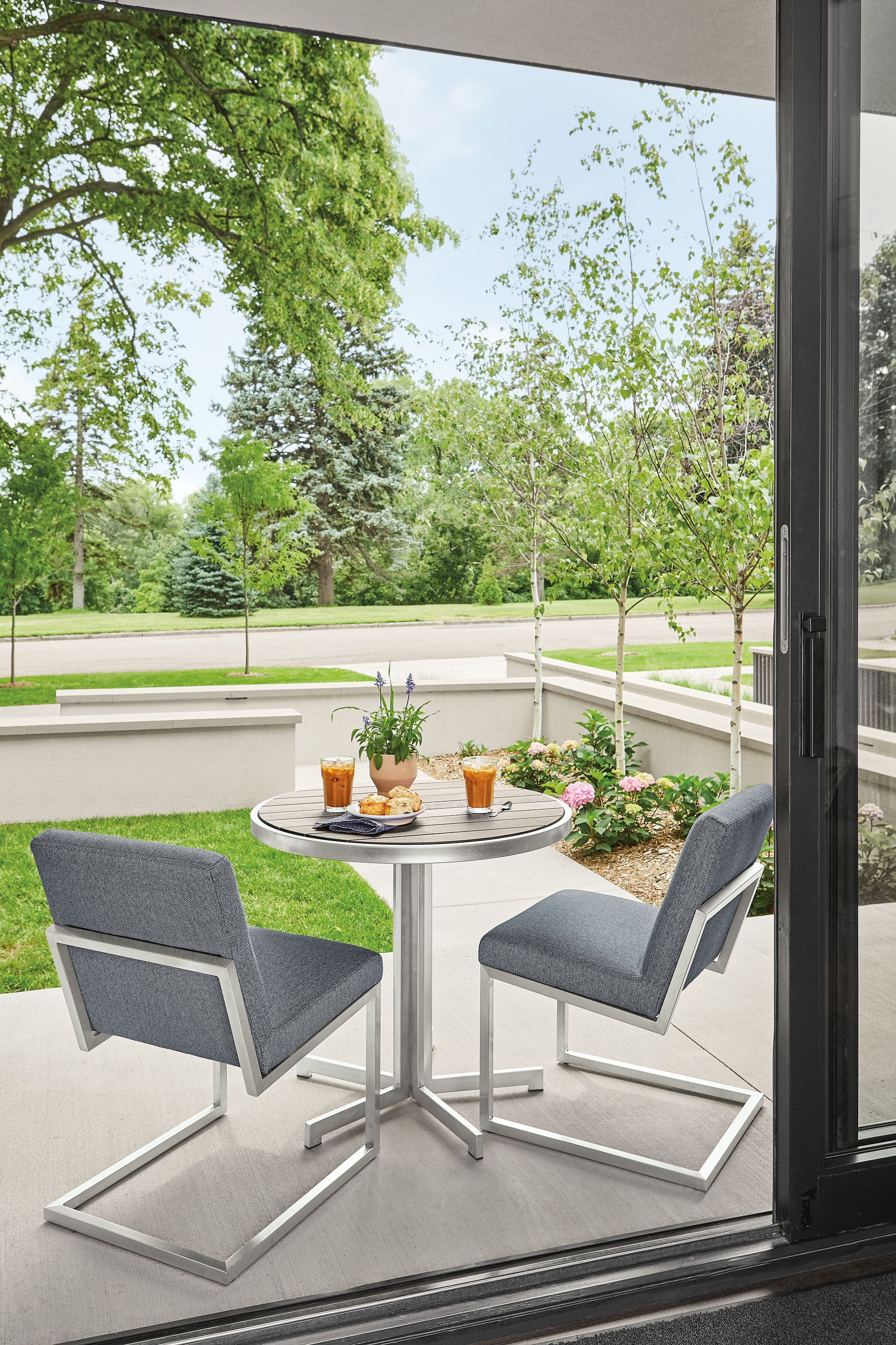 outdoor patio with finn side chairs in mist fabric and montego round table in aged ash.