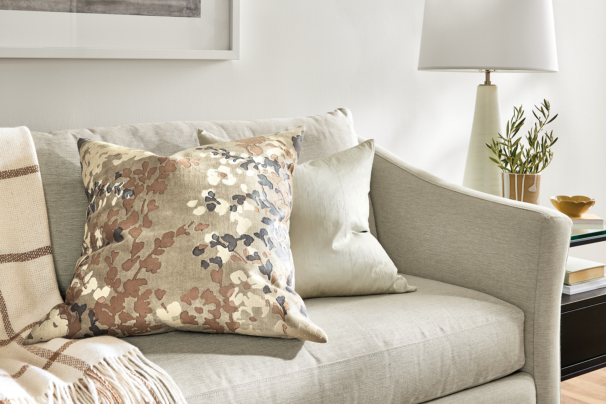 fleur pillow and silk pillow on top of maeve sofa.