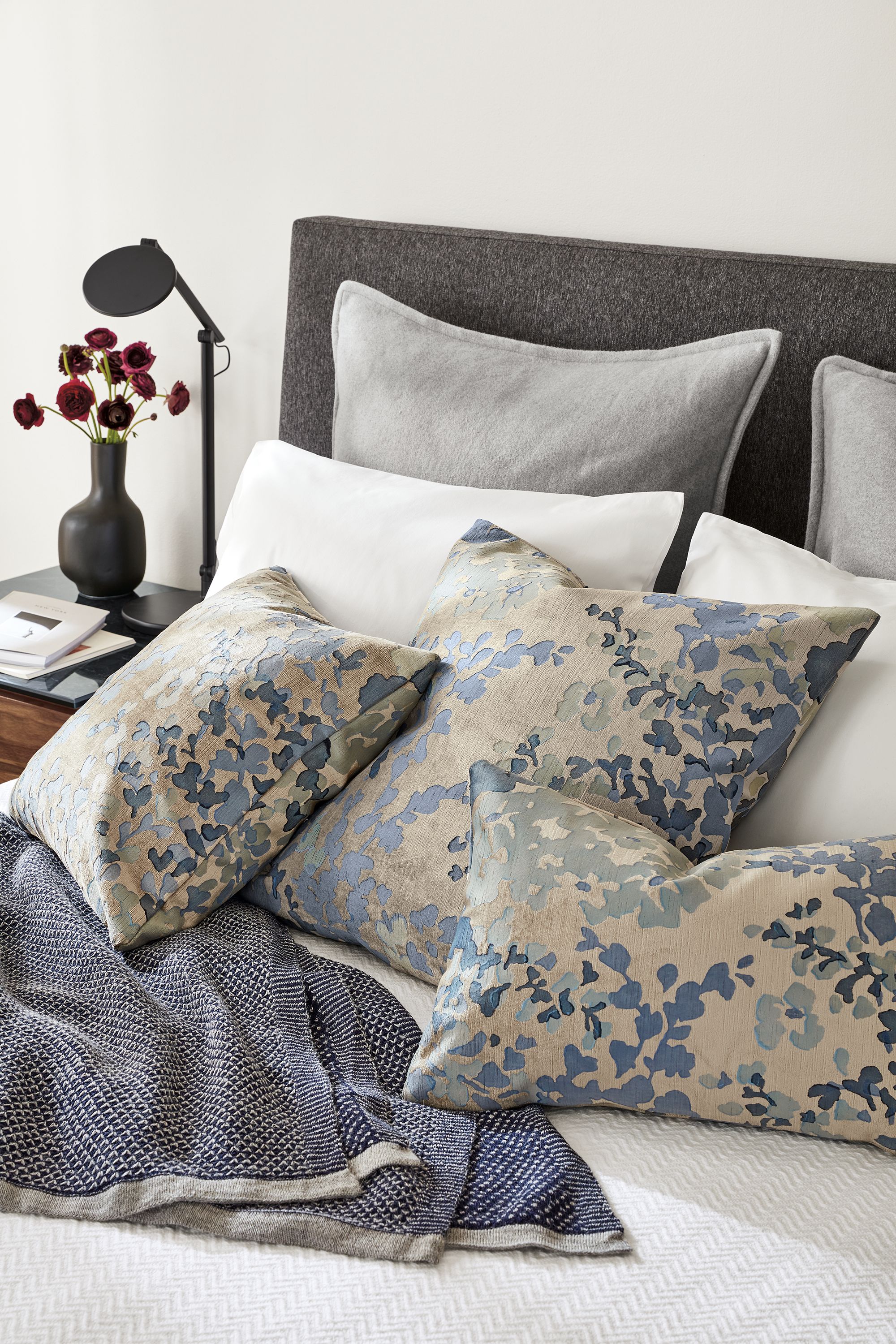 detail of bed with fleur pillows in blue.
