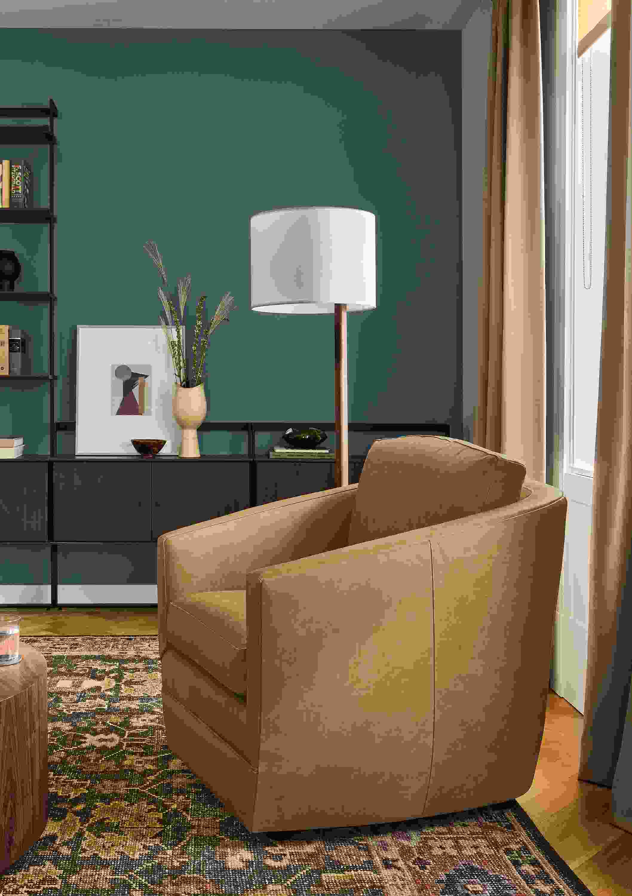 Living room with Ford chair in Palermo Camel leather, Beam bookcases in charcoal on ash and Tillia rug in brick.