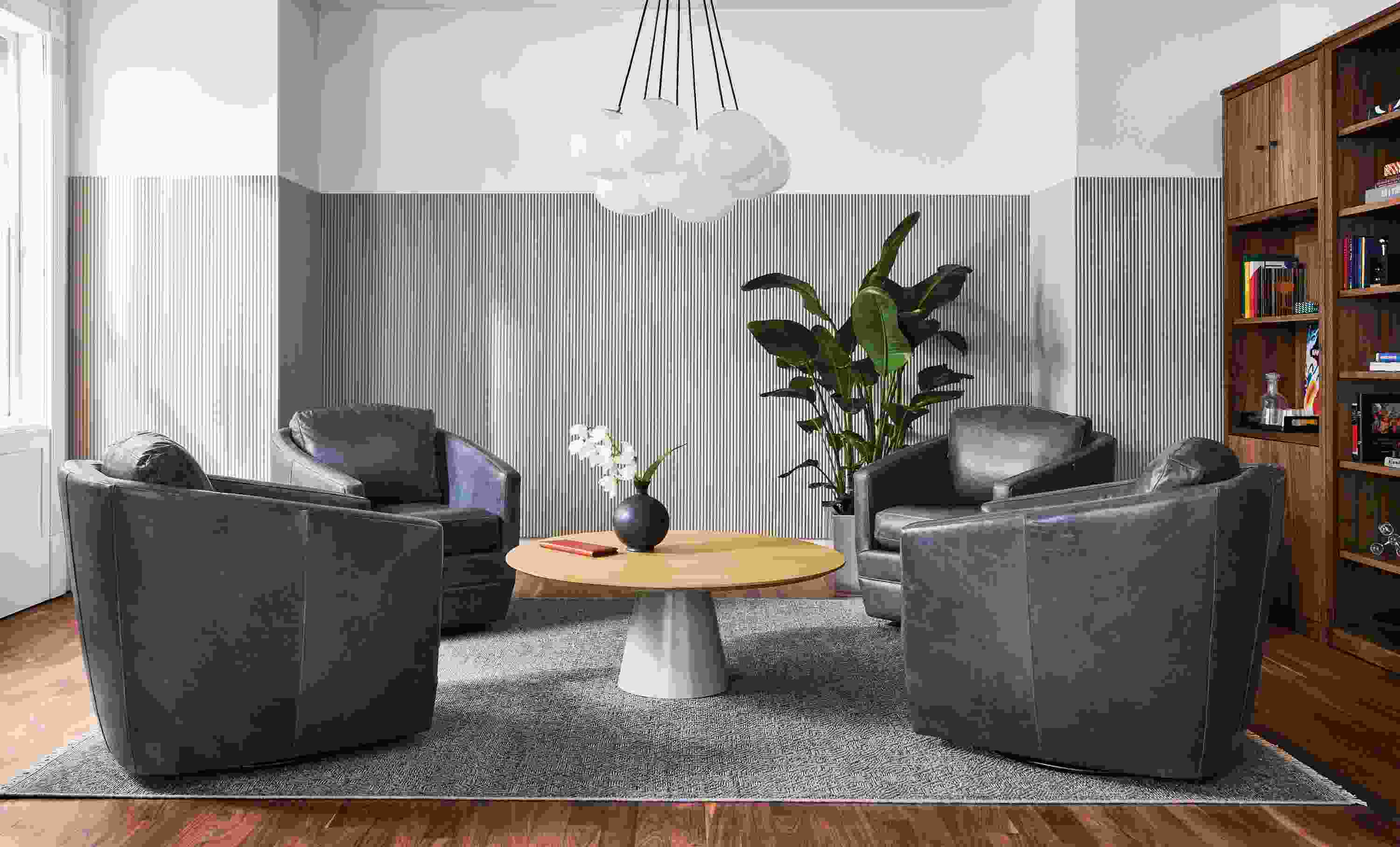Four Ford Swivel Chairs in Vento Ink with Decker 42-round coffee table, woodwind bookcases and humboldt globe chandelier.