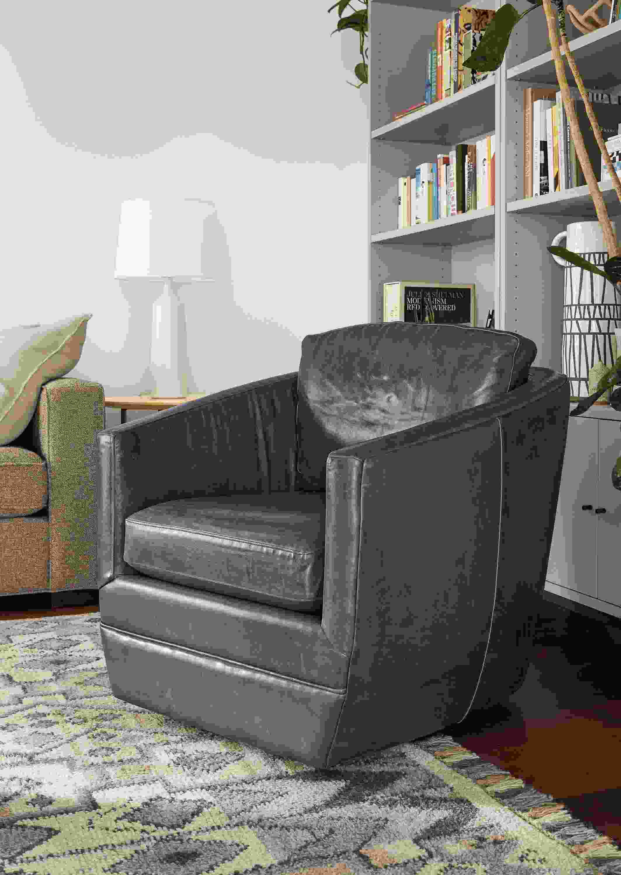 Detail of Ford swivel chair in Vento Ink leather in living room with Ona rug.