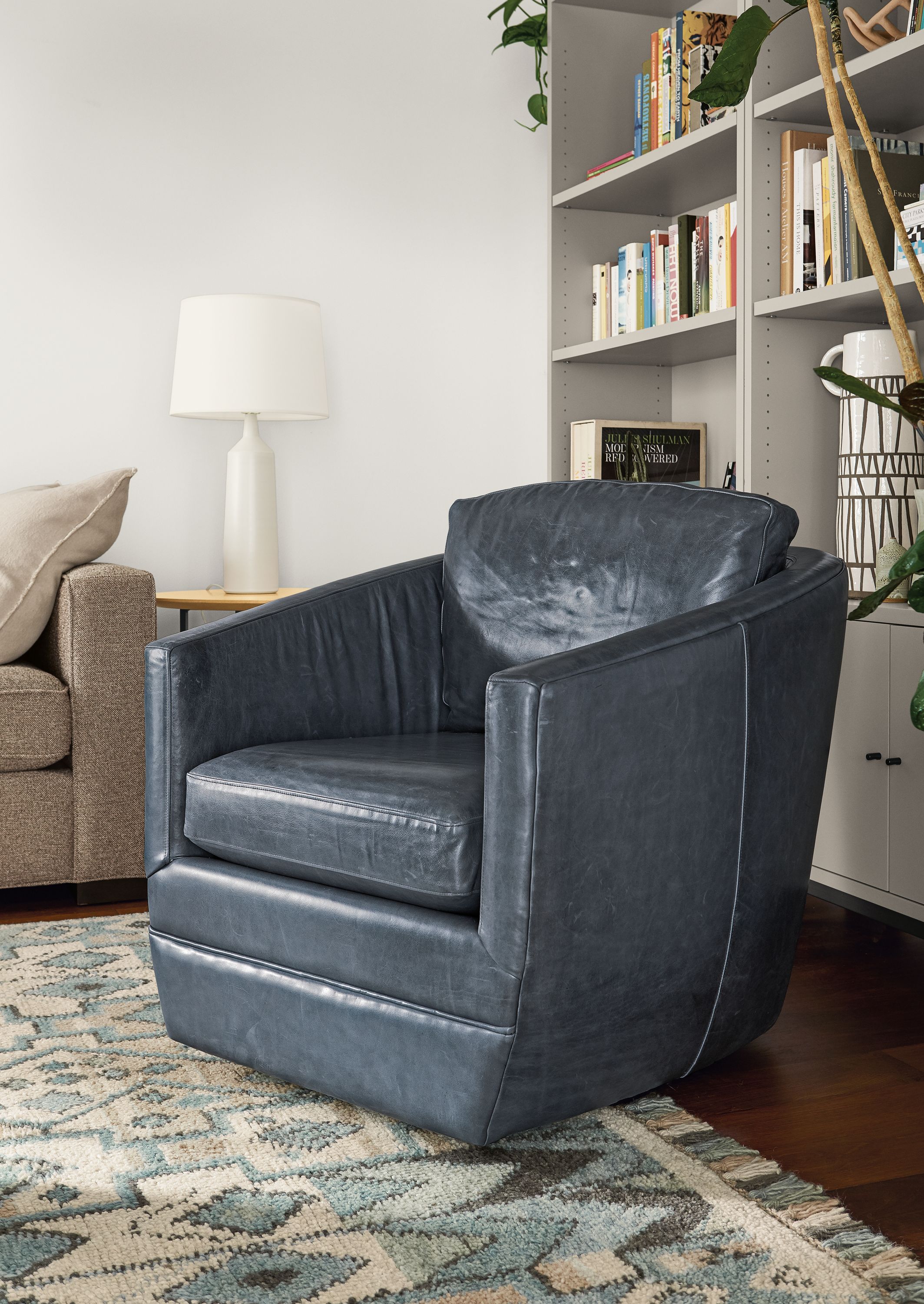 Detail of Ford swivel chair in Vento Ink leather in living room with Ona rug.