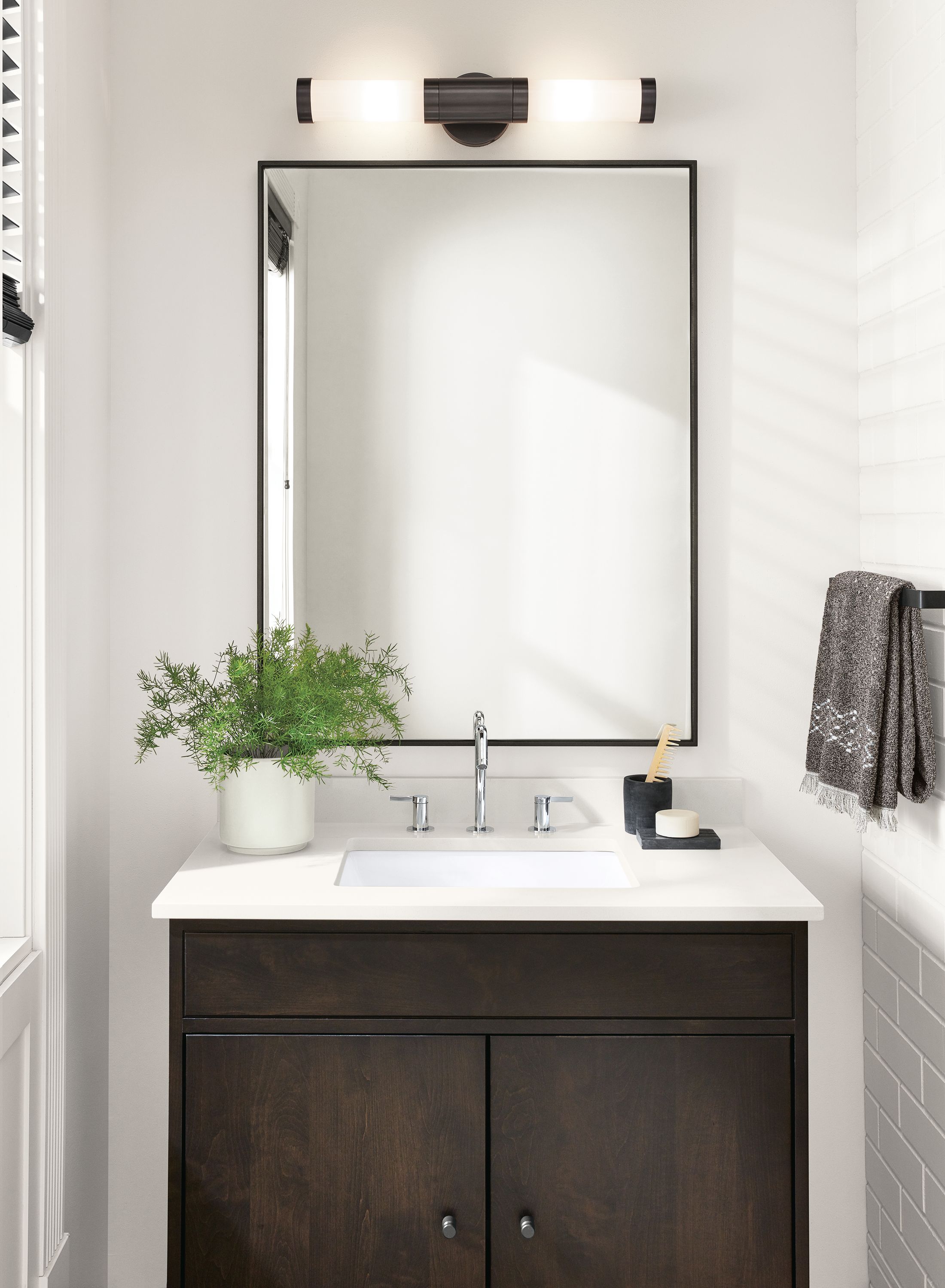 Brass sconces above bathroom vanity