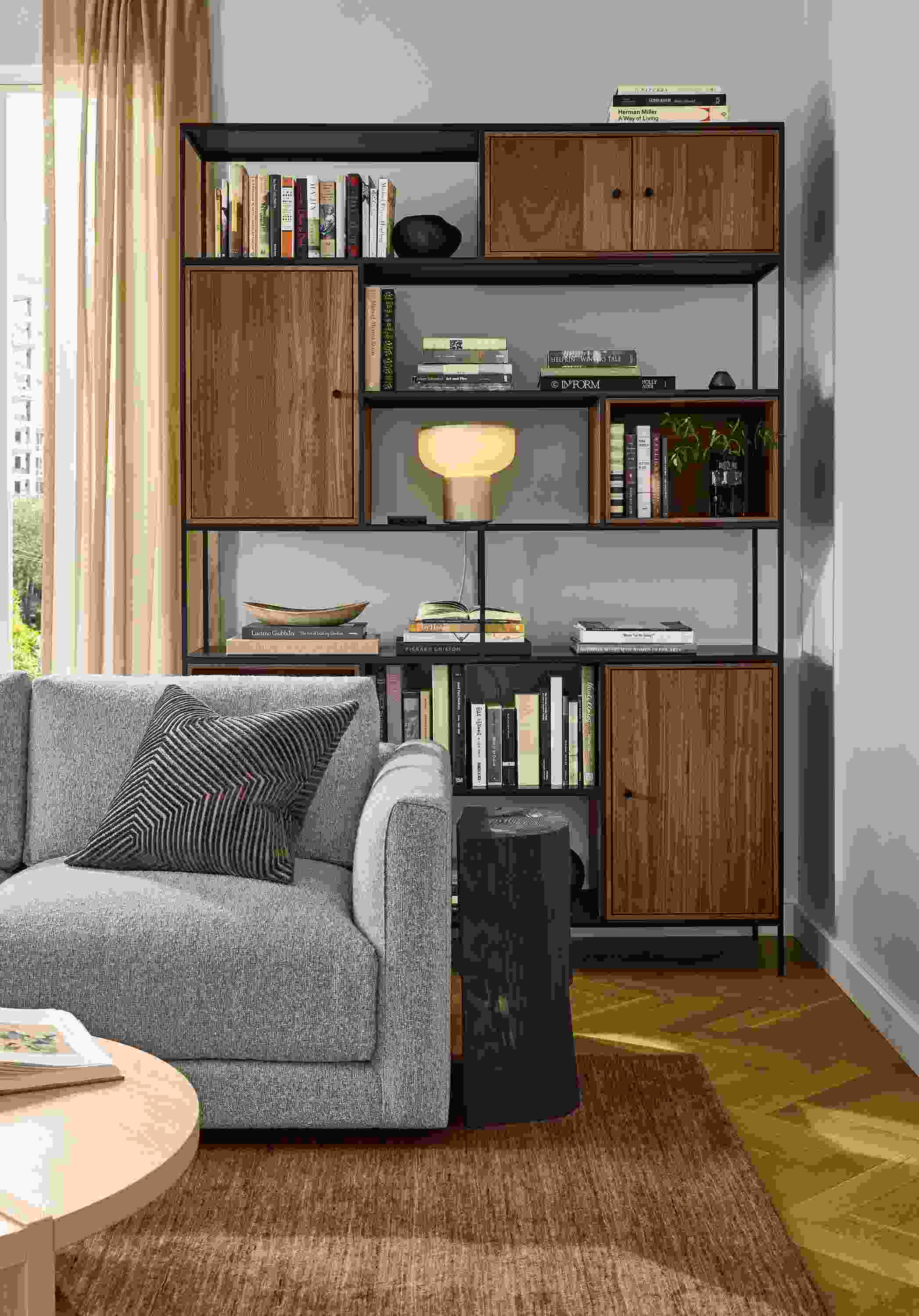 Living room with Foshay 60-wide bookcase in natural steel with walnut inserts and Clemens sofa in Conley Grey.