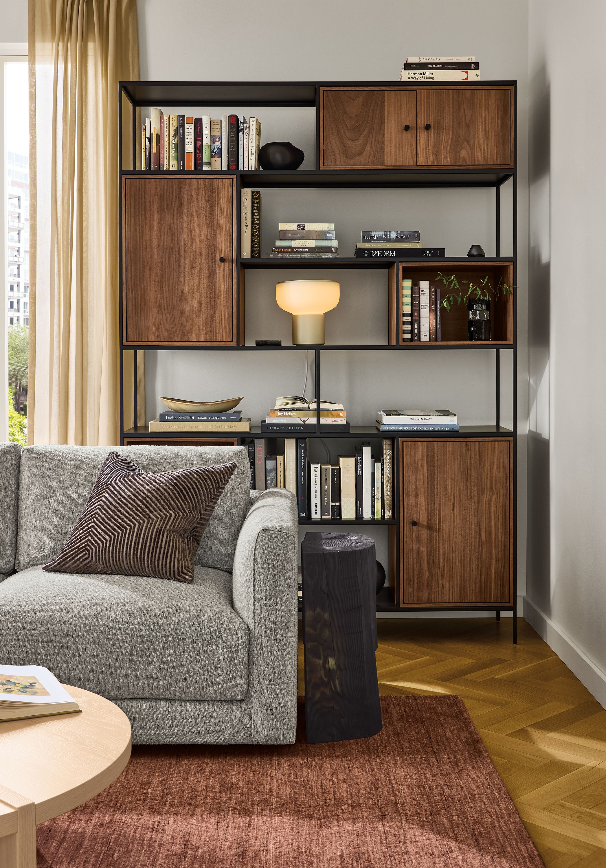 Living room with Foshay 60-wide bookcase in natural steel with walnut inserts and Clemens sofa in Conley Grey.
