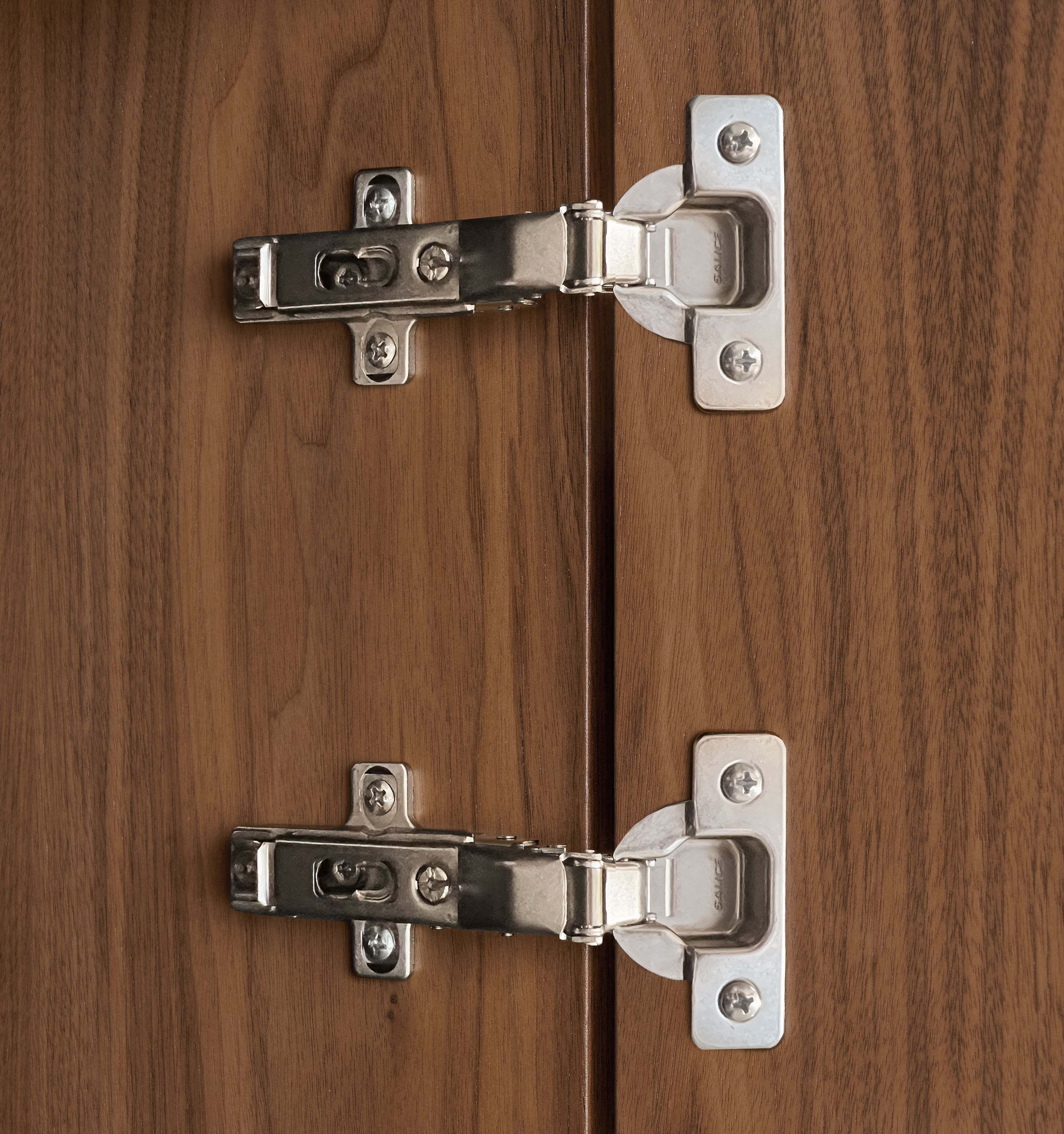 Detail of Foshay door hinges on walnut bookcase insert.