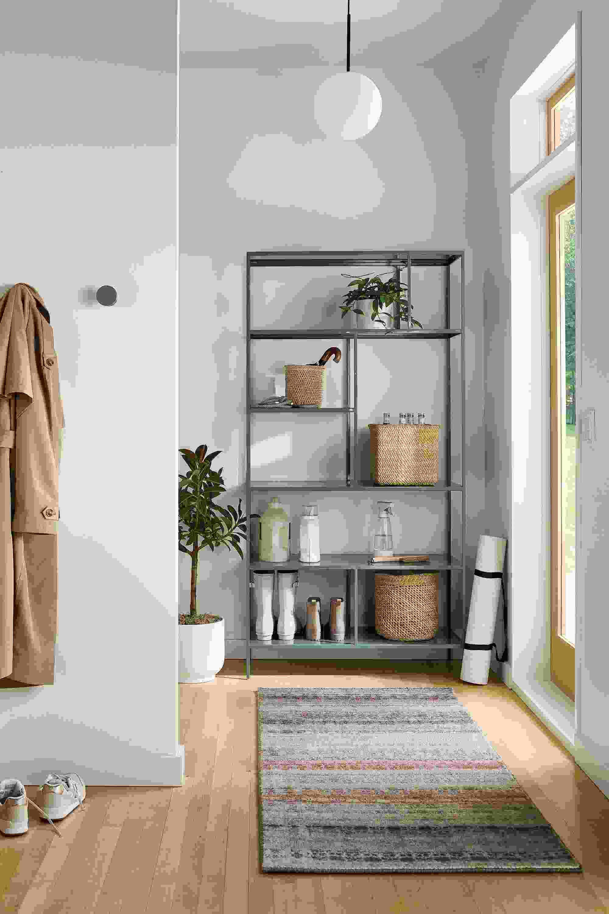 Entryway with Foshay 36-wide bookcase in cadet, Varun 2.5 by 6 rug in multicolor and Orbit pendant in matte black.