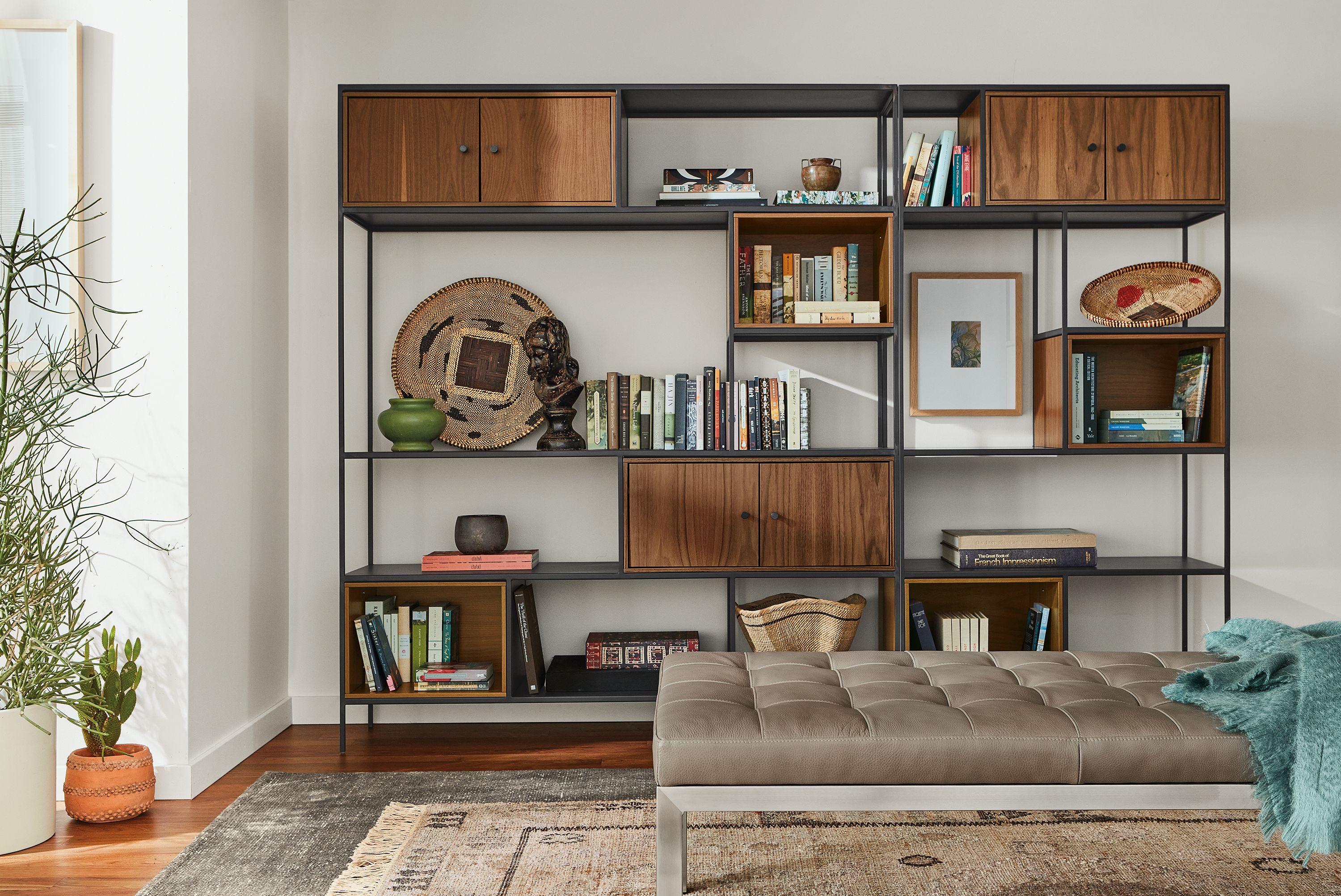 Living room with Foshay bookcase wall unit in natural steel with inserts in walnut and Ravella daybed in Pesaro Putty leather.