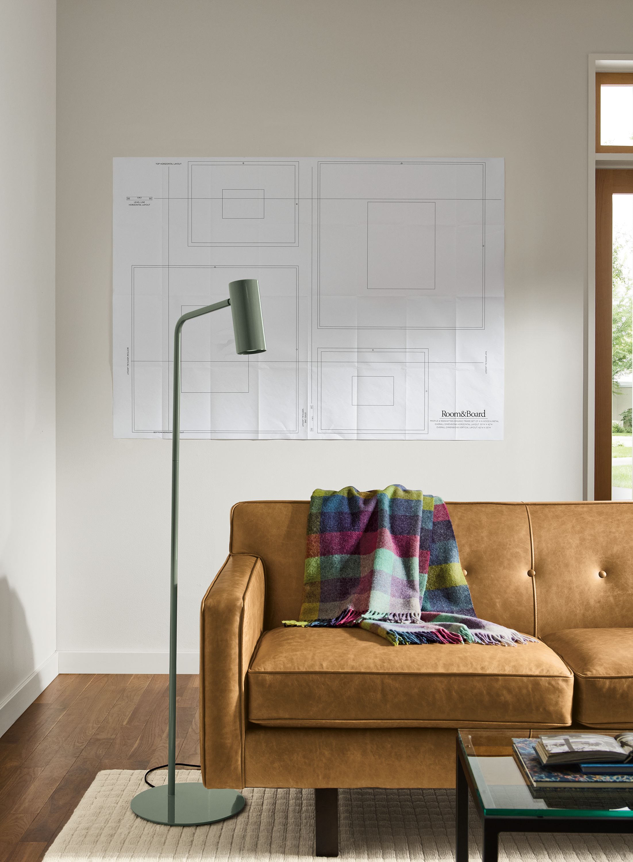 Living room with a paper template on the wall for arranging 2 profile and 2 manhattan frame sets.
