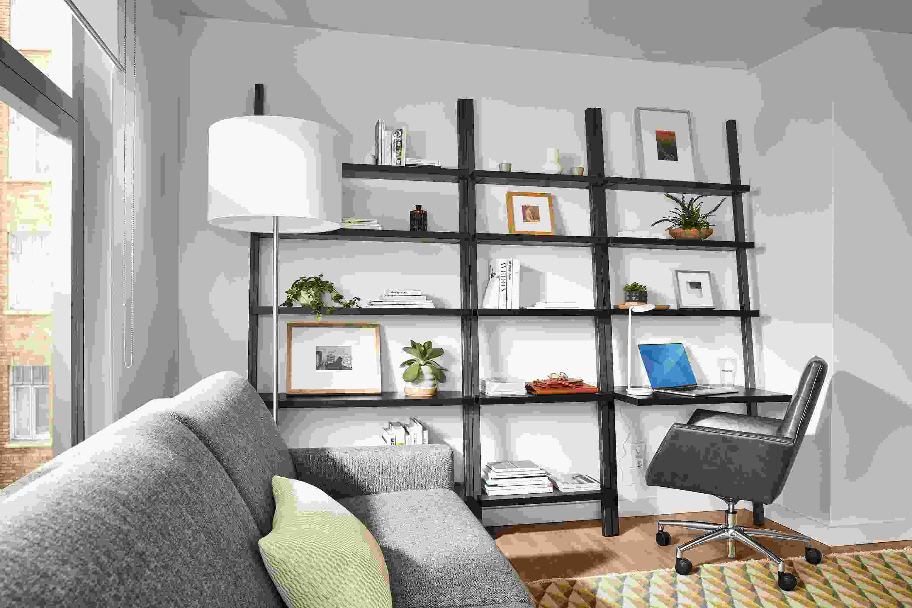 Living room setting with Gallery Leaning Shelves in Natural Steel and Charcoal Reclaimed Wood and Tenley Office Chair in Vento Smoke