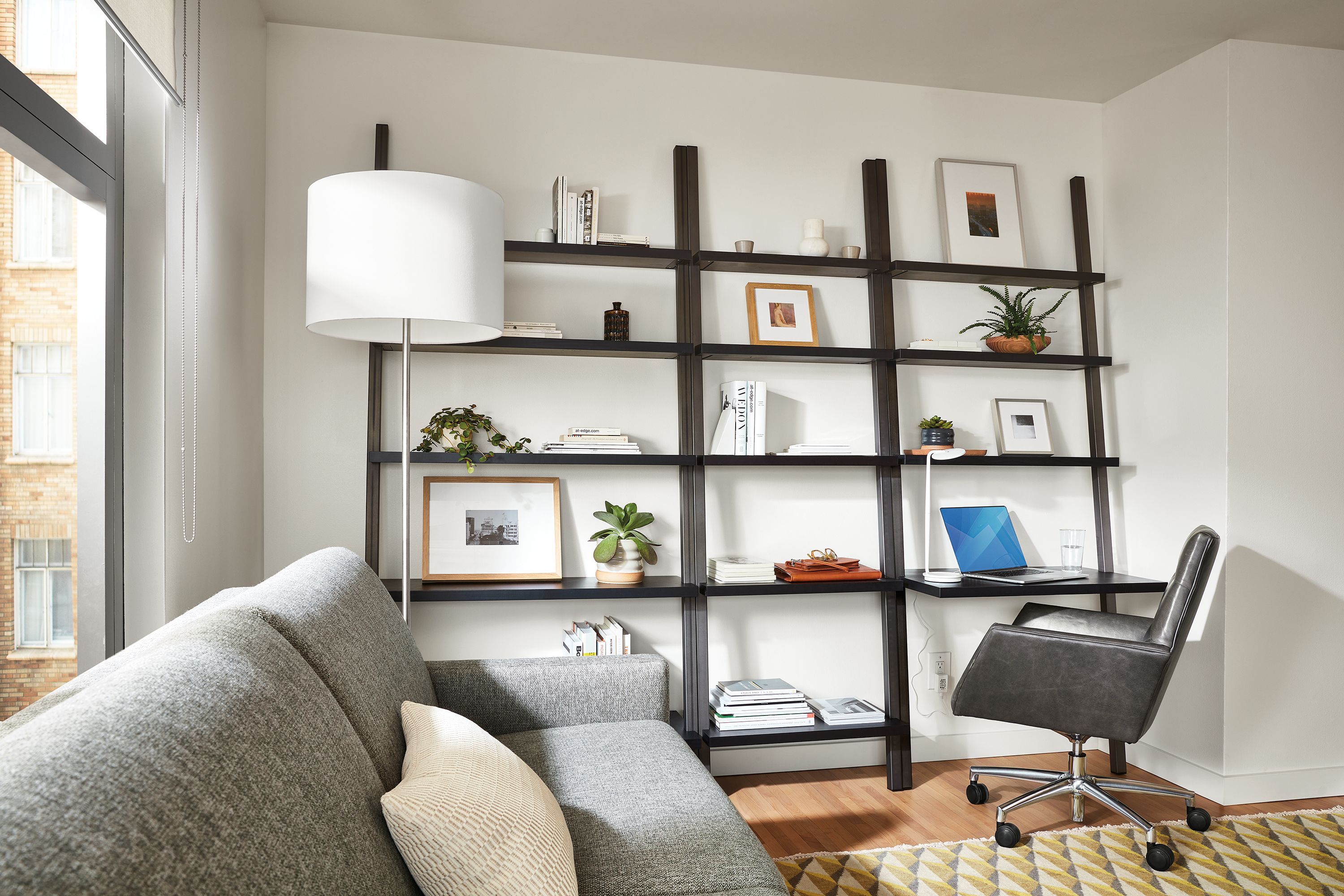 Living room setting with Gallery Leaning Shelves in Natural Steel and Charcoal Reclaimed Wood and Tenley Office Chair in Vento Smoke