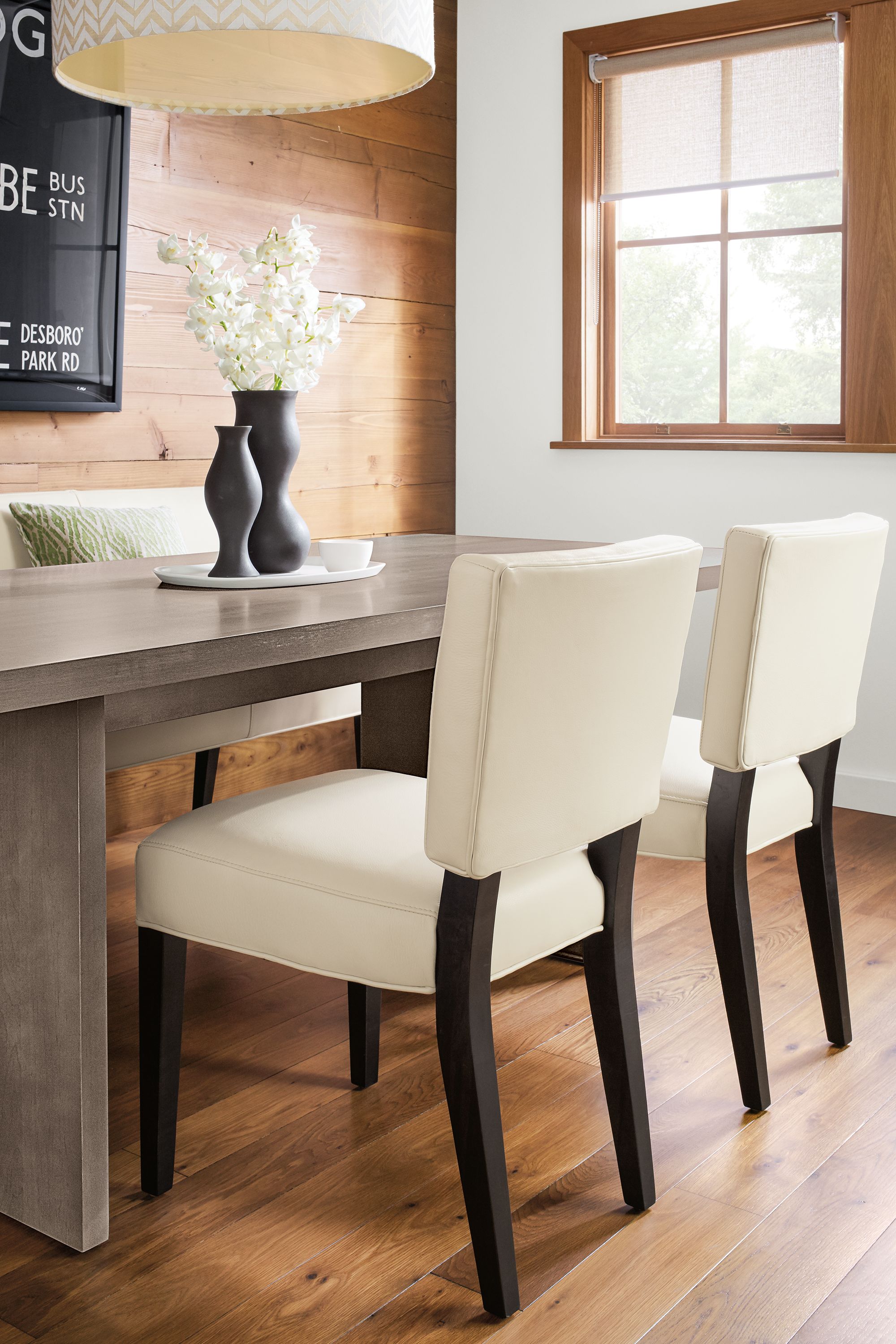 Dining area with 2 Georgia side chairs and Georgia bench in Pesaro Ivory leather and charcoal legs.