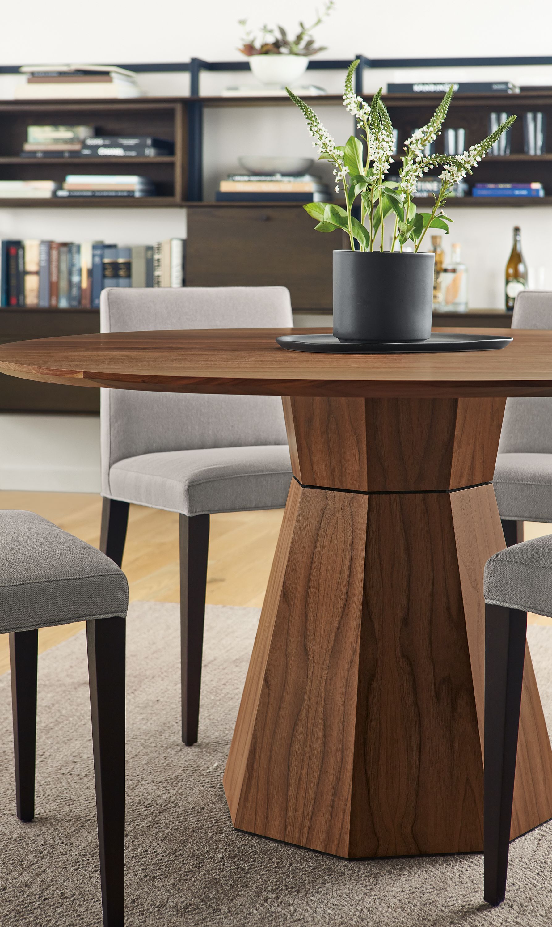 Dining space with Glover round dining table in walnut, 4 Ava side chairs in Flint Cement and Avilia rug in foxhound.