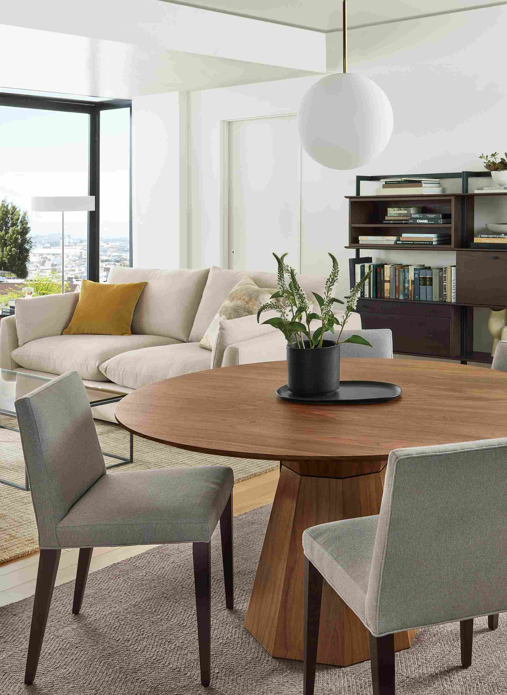Dining space with Glover dining table in walnut, Ava chairs in Flint Cement and Orbit pendant.