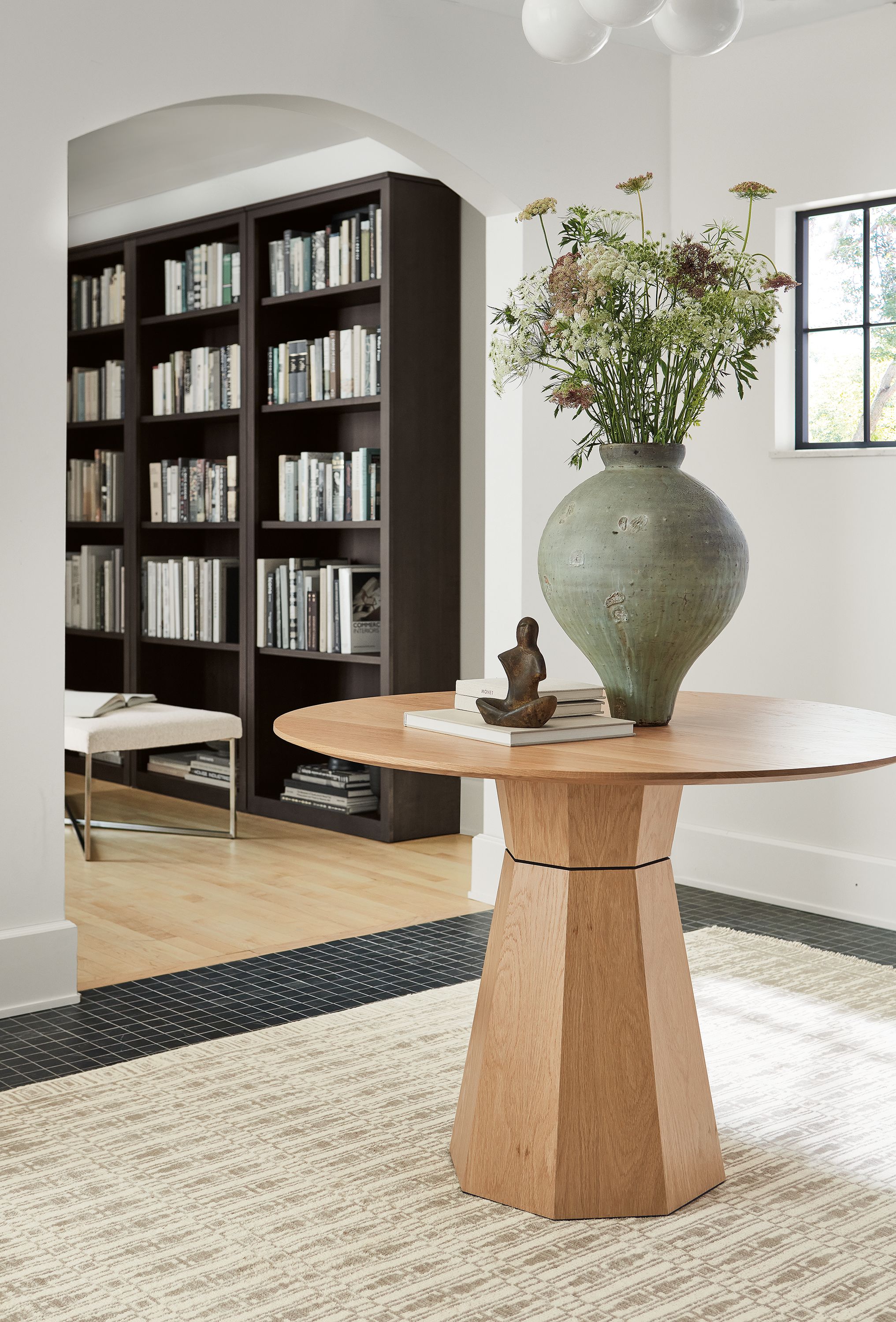 Entryway with Glover 42-diameter round table in rye on red oak and Tulum 6 by 9 rug Taupe.