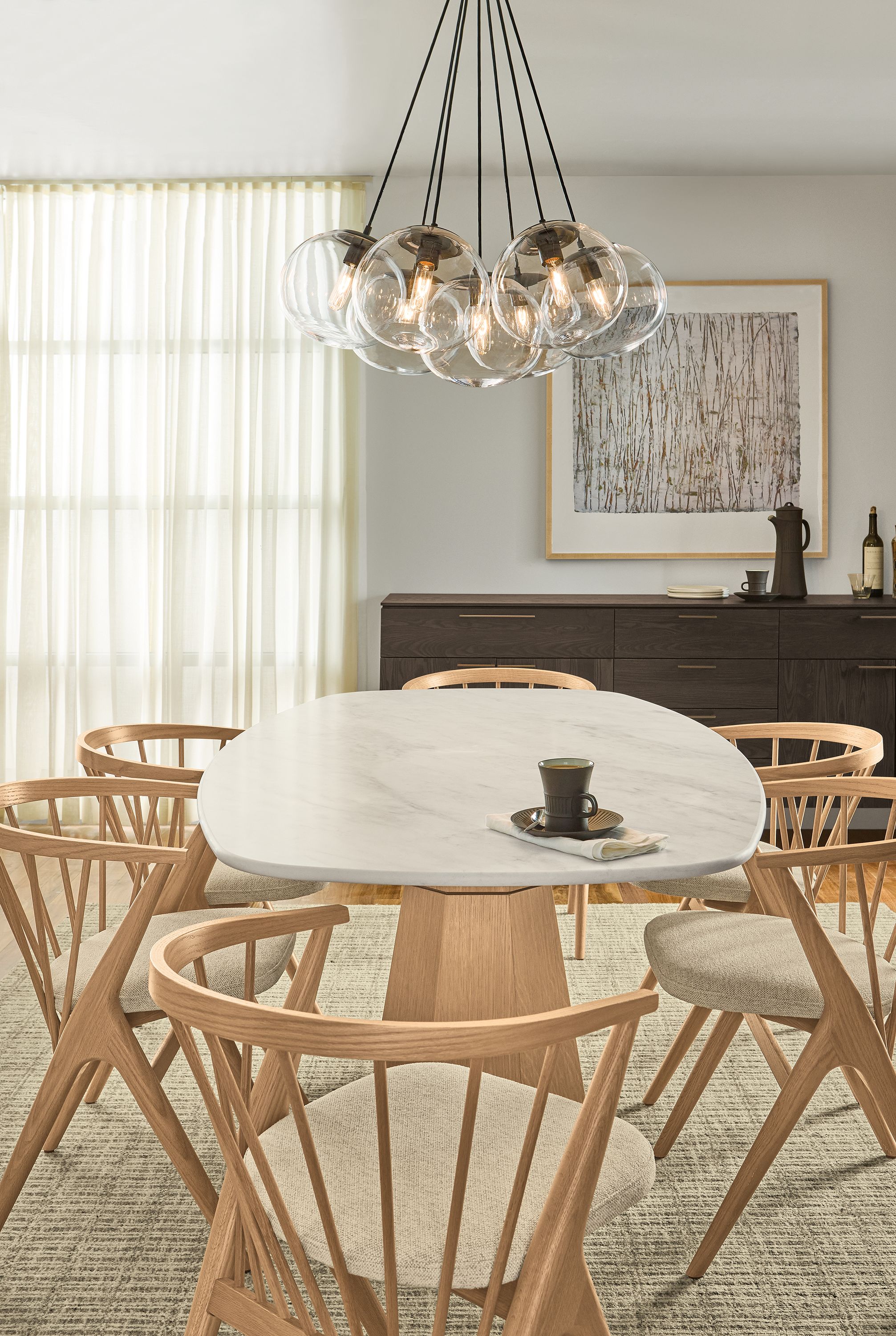 Dining room with Glover boat top table in rye on red oak with marbled warm white quartz top and 6 Soren arm chairs in rye on red oak.