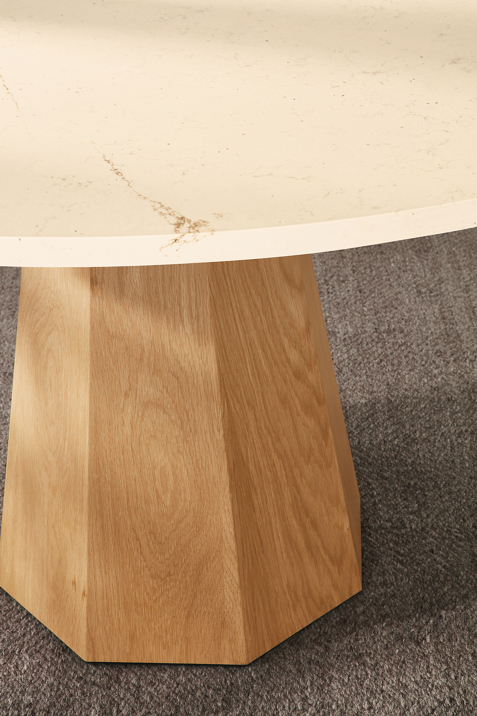 Detail of Glover 48 diameter round table in white oak with ecru quartz top and Avilia 8 by 10 rug in foxhound.