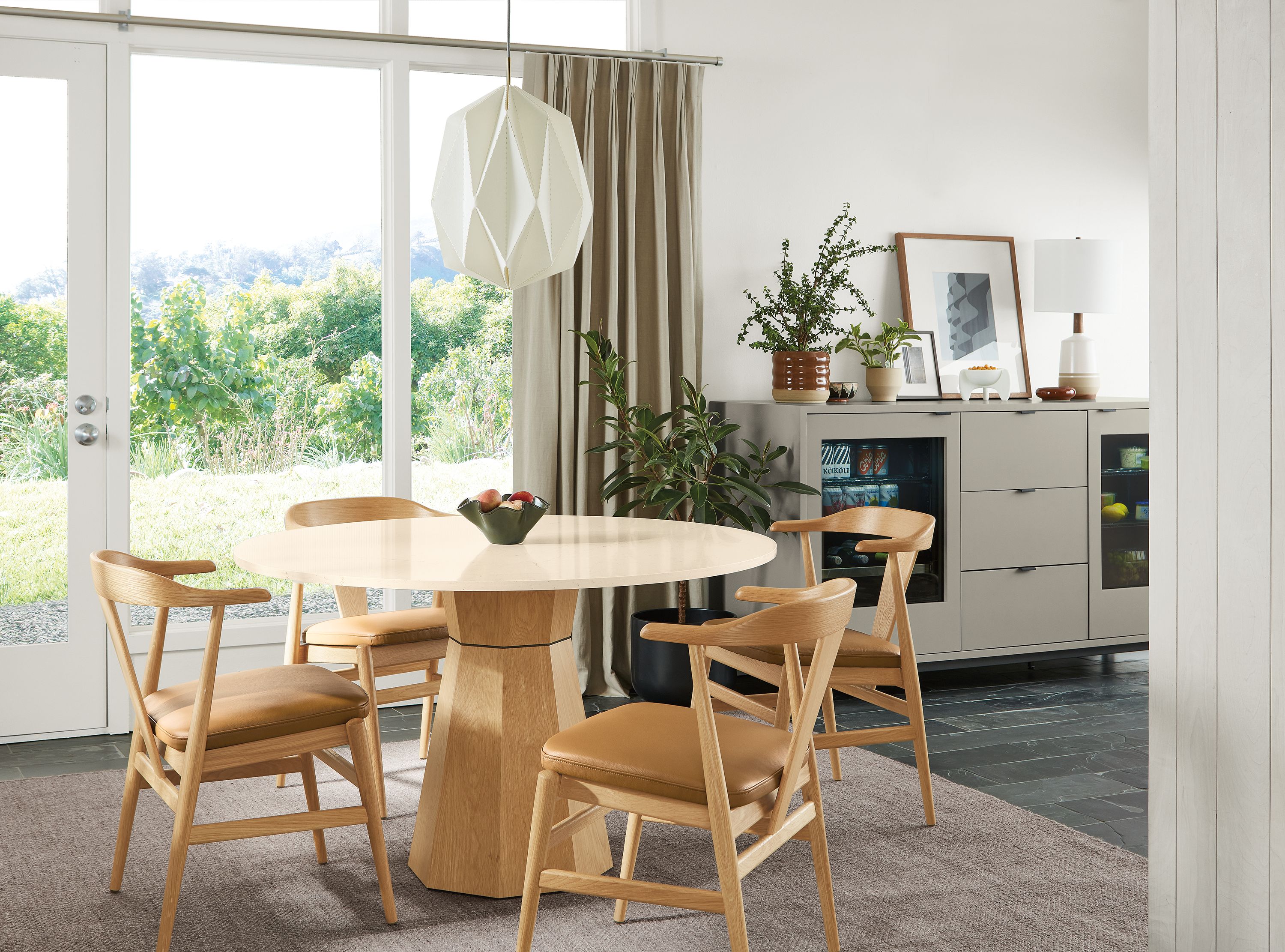 Dining room with a Glover 48 diameter round table in white oak, evan arm chairs in white oak with Pesaro Camel leather seats.