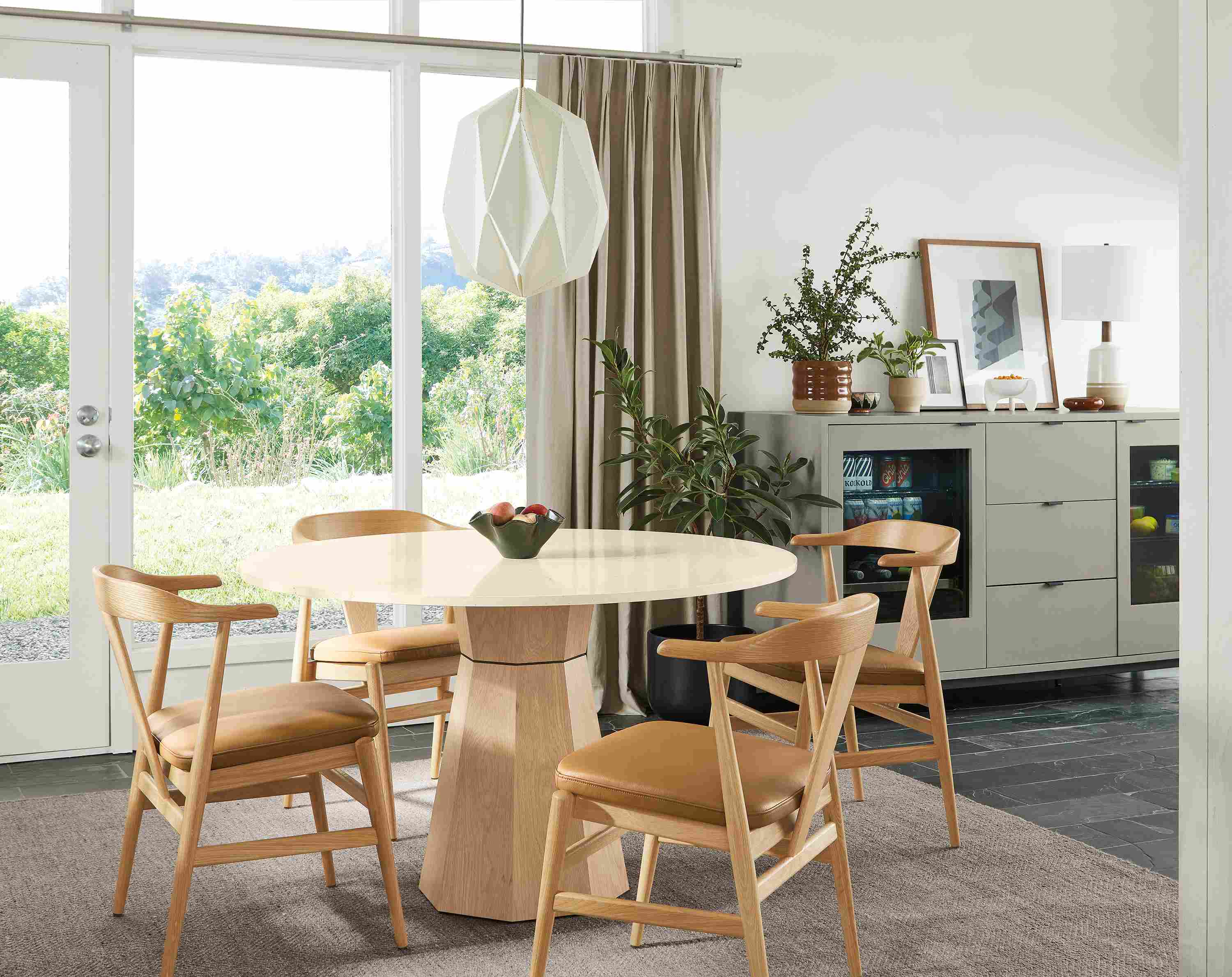 Dining room with a Glover 48-diameter round table in salt on red oak, Evan arm chairs in white oak with Pesaro Camel leather seats.