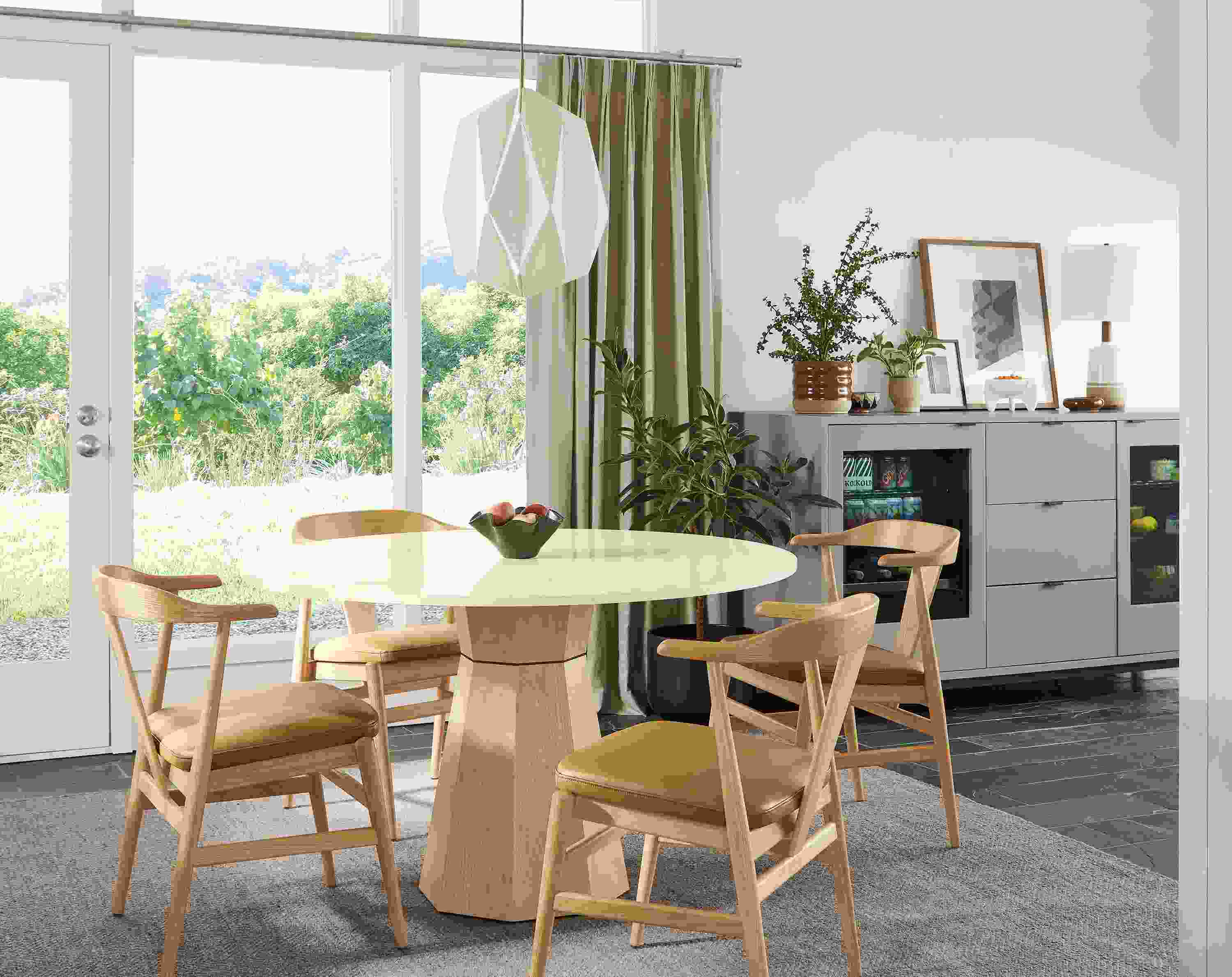 Dining room with a Glover 48-diameter round table in salt on red oak, Evan arm chairs in white oak with Pesaro Camel leather seats.