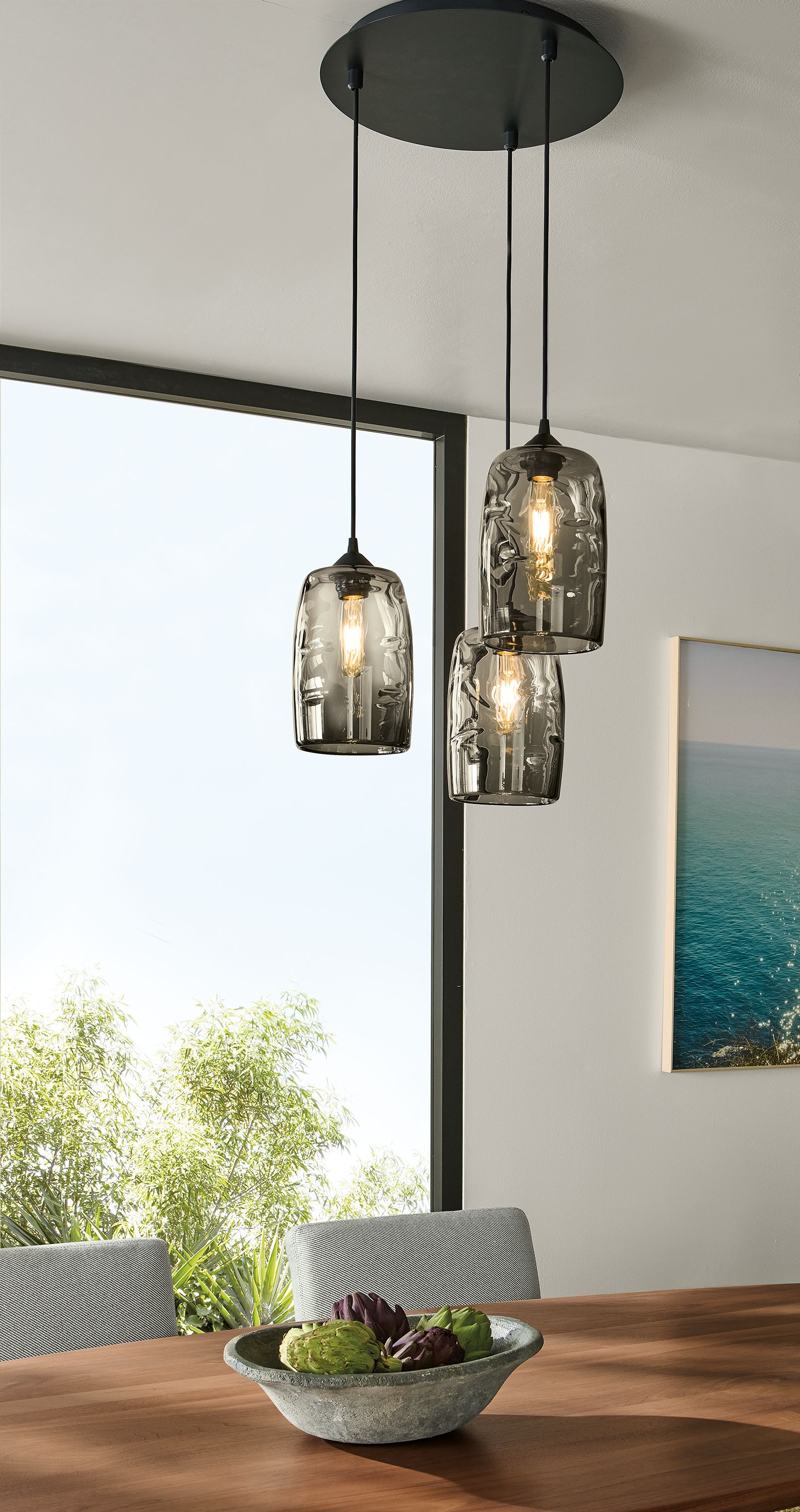 Dining room with detail of Glow 3-cylinder pendants in smoke glass with round graphite ceiling plate.