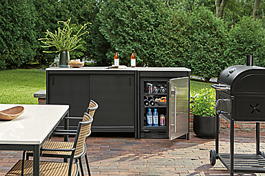 Outdoor space with granger modular outdoor kitchen set with fridge with door open.