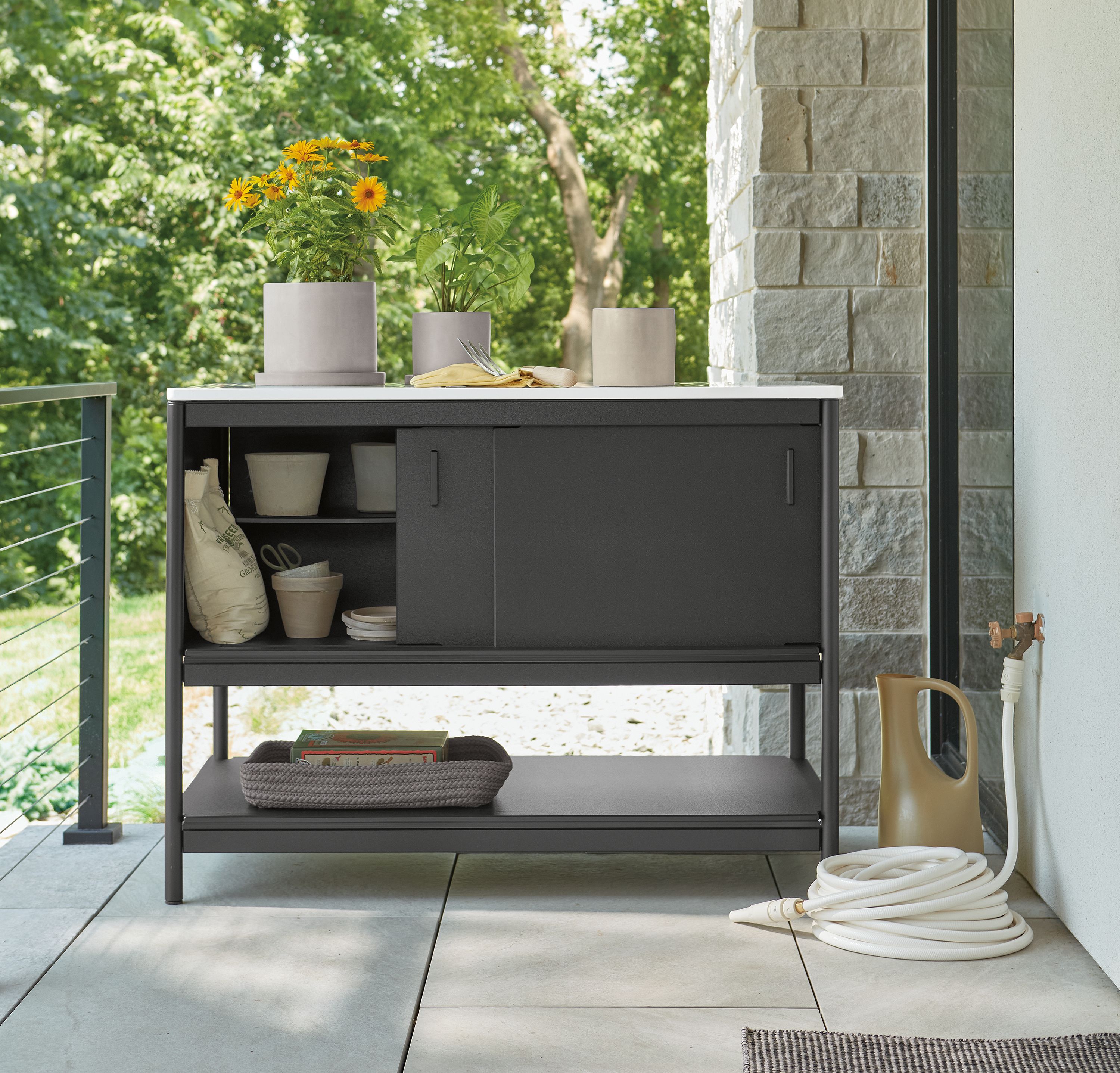 Indoor/outdoor space with Granger 48-wide outdoor kitchen half-storage cabinet in black HDPE with quartz top.