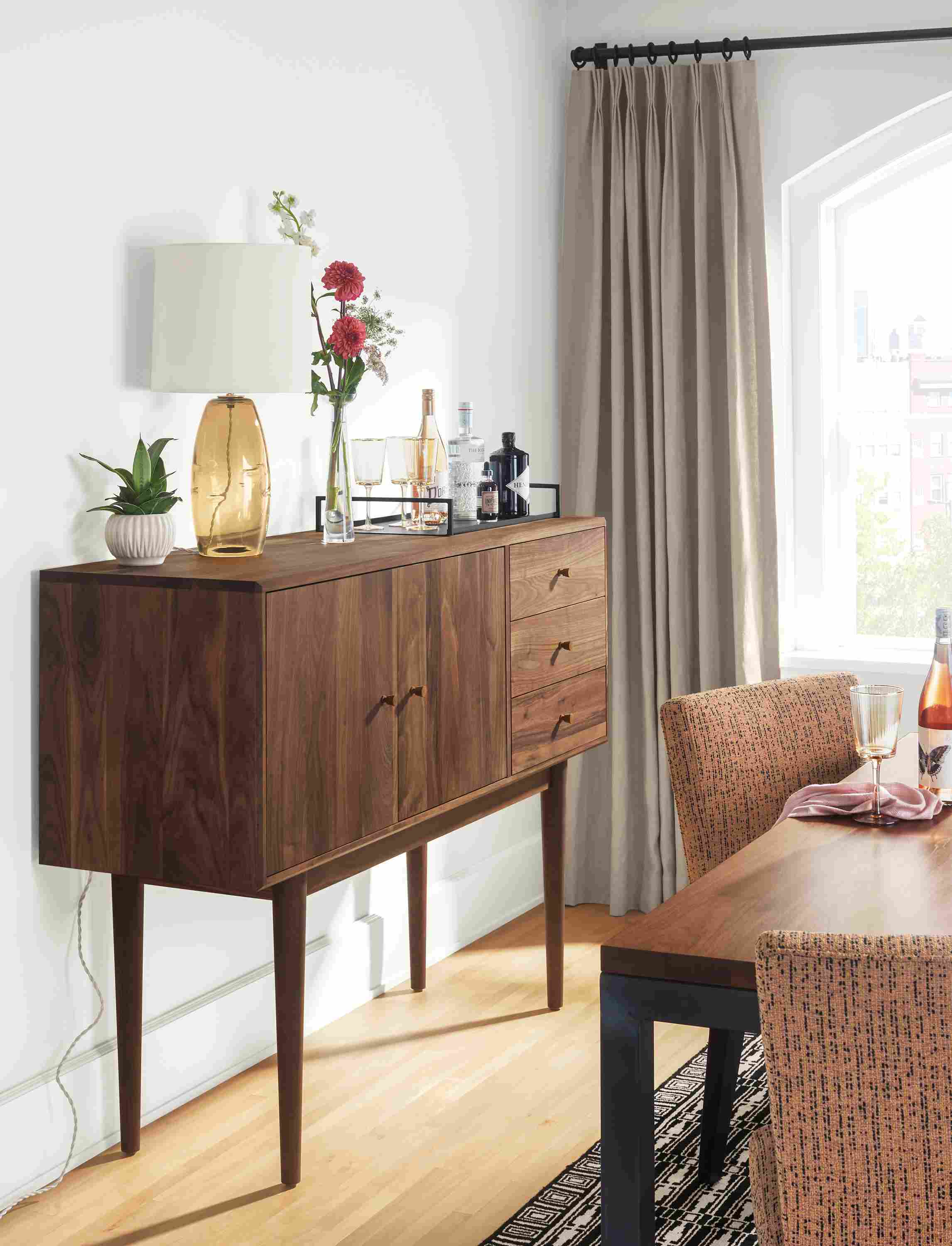 Detail of Grove storage cabinet in walnut in dining room with Parsons table and Georgia side chairs.