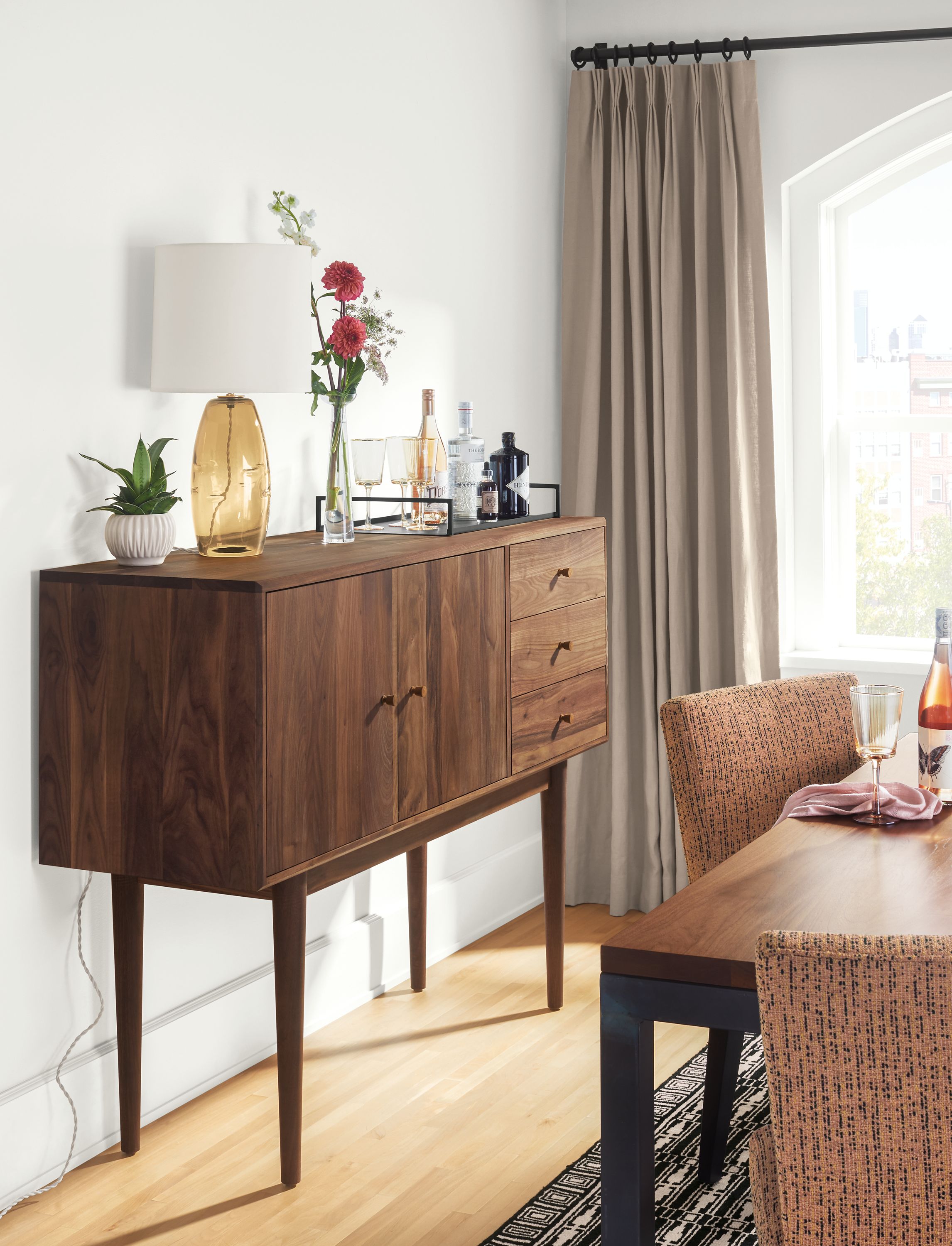 Detail of Grove storage cabinet in walnut in dining room with Parsons table and Georgia side chairs.