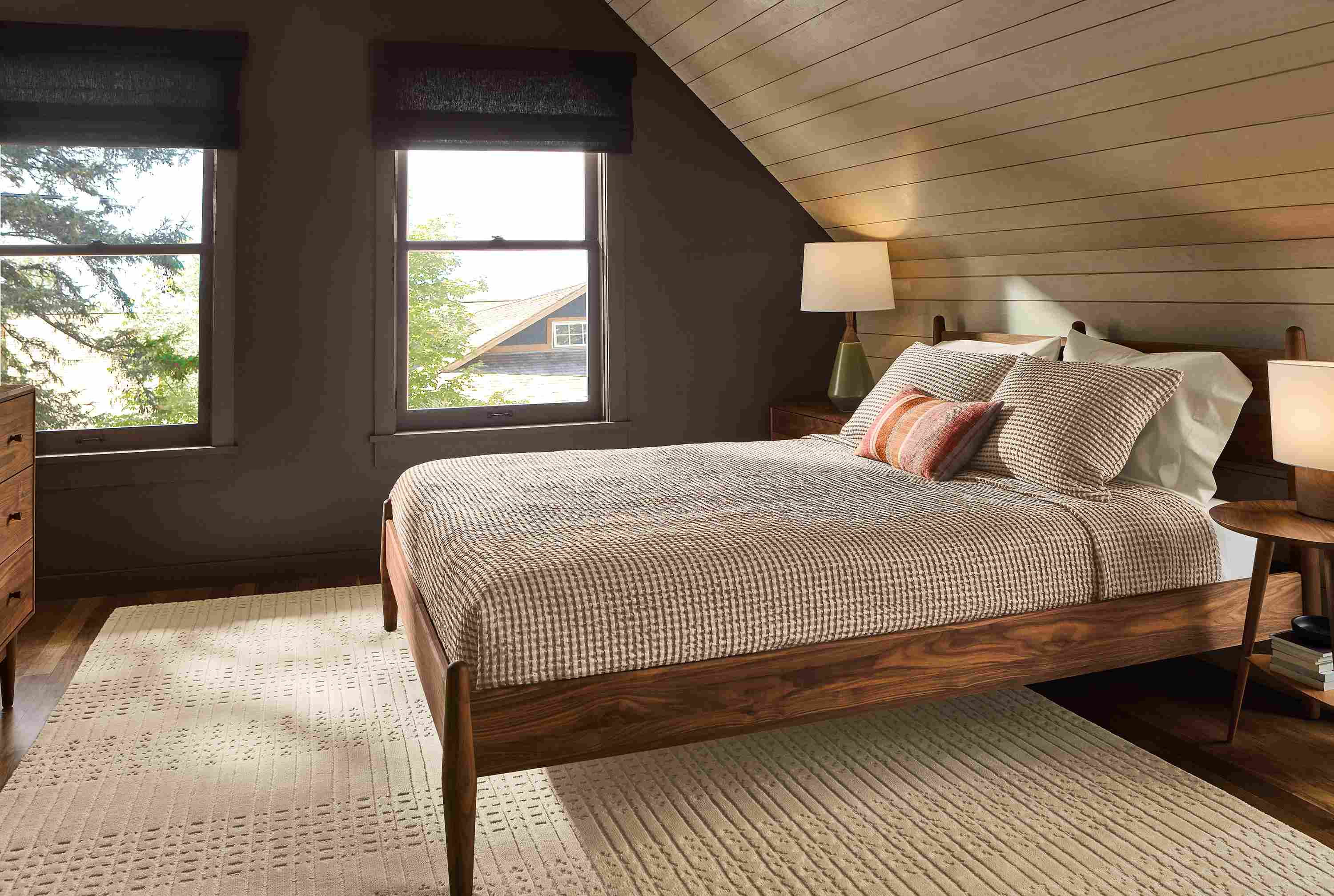 Bedroom with Grove queen bed, dresser and nightstand in walnut, Bria rug in ivory and Westin coverlet in brick.
