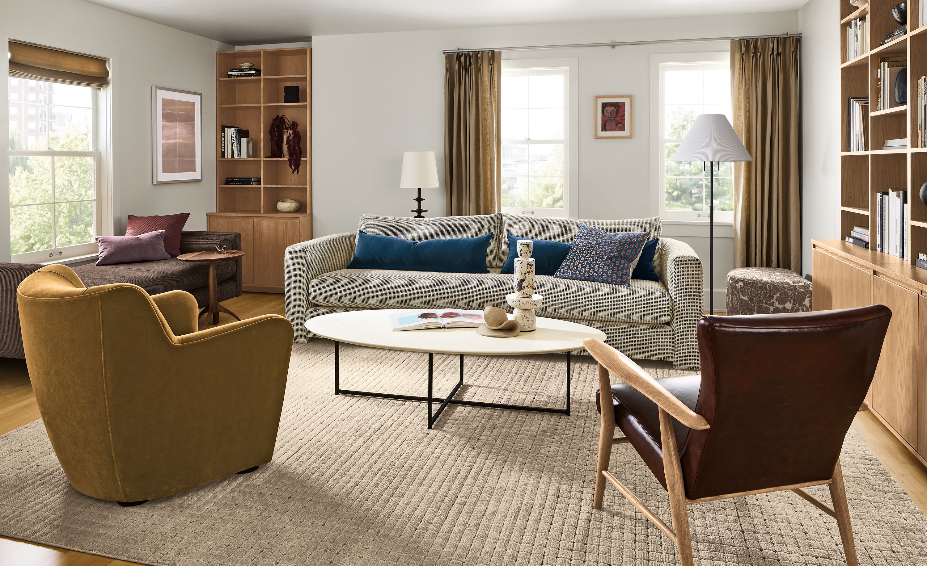 Living room with Hannah 106-wide bench cushion sofa in Dorsa Mink and Jonas chair in Vento Merlot leather.