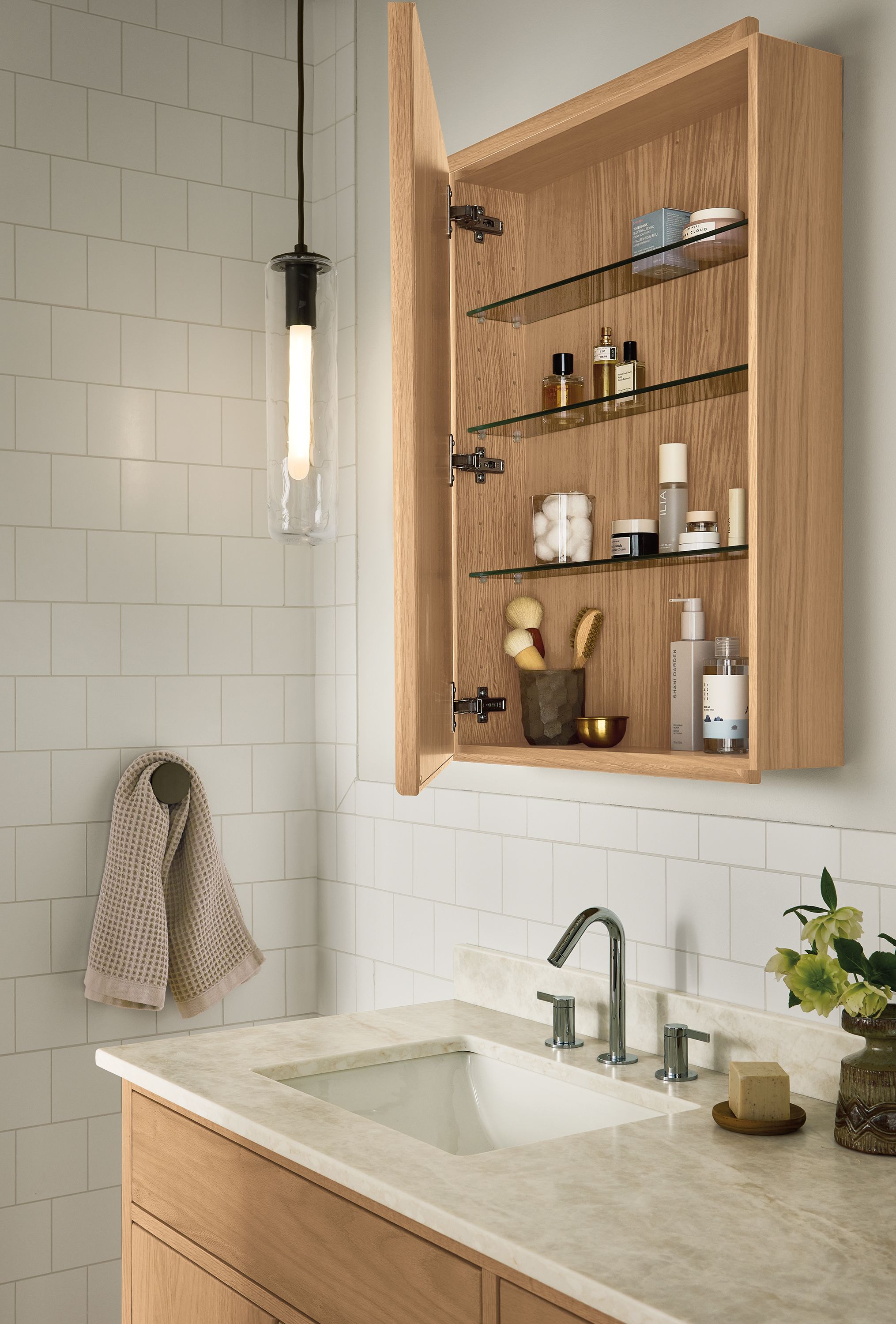 Bathroom with Harlan medicine cabinet in rye on red oak shown open revealing glass shelves.