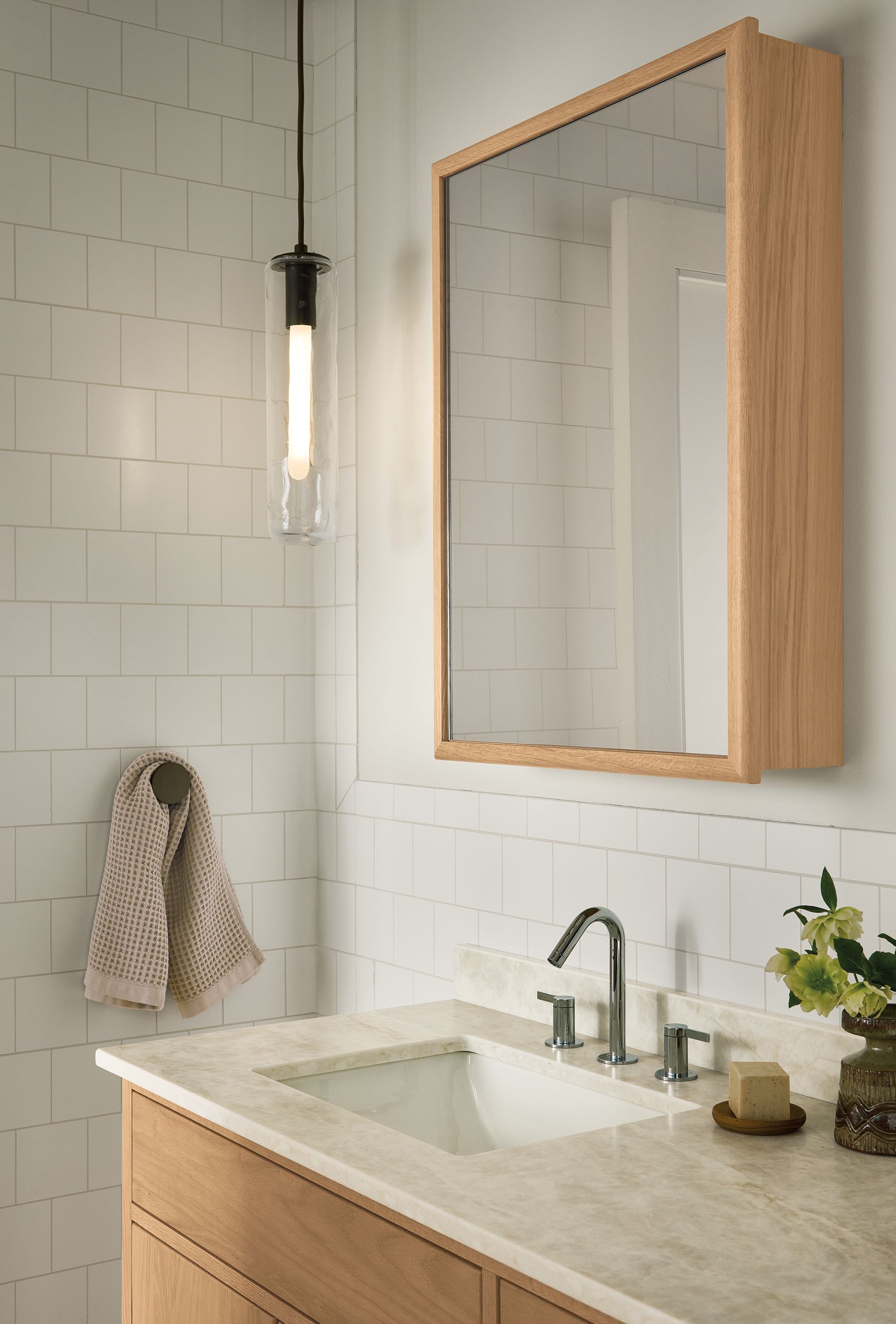 Bathroom with Harlan 23-wide medicine cabinet and Berkely vanity, both in rye on red oak and Ursa clear glass pendant.