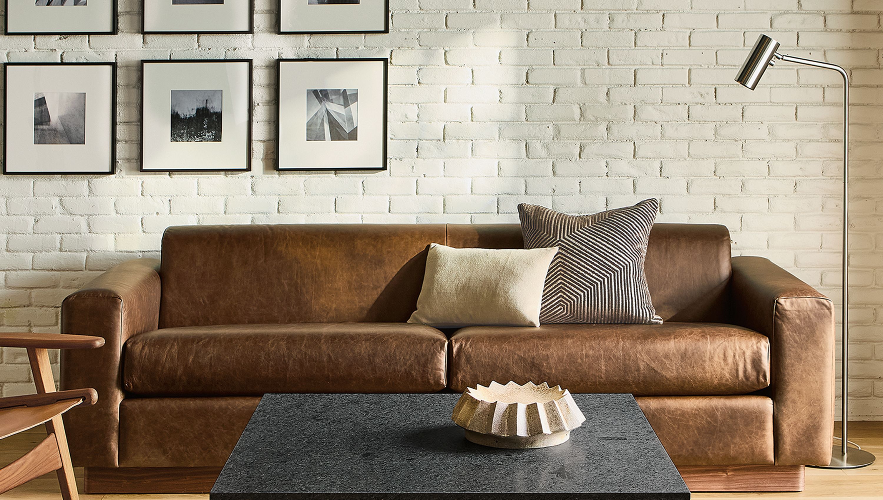 Living room with Harmon 95-wide sofa in Palermo Bourbon leather and Parsons table in Mesabi Black granite and natural steel.
