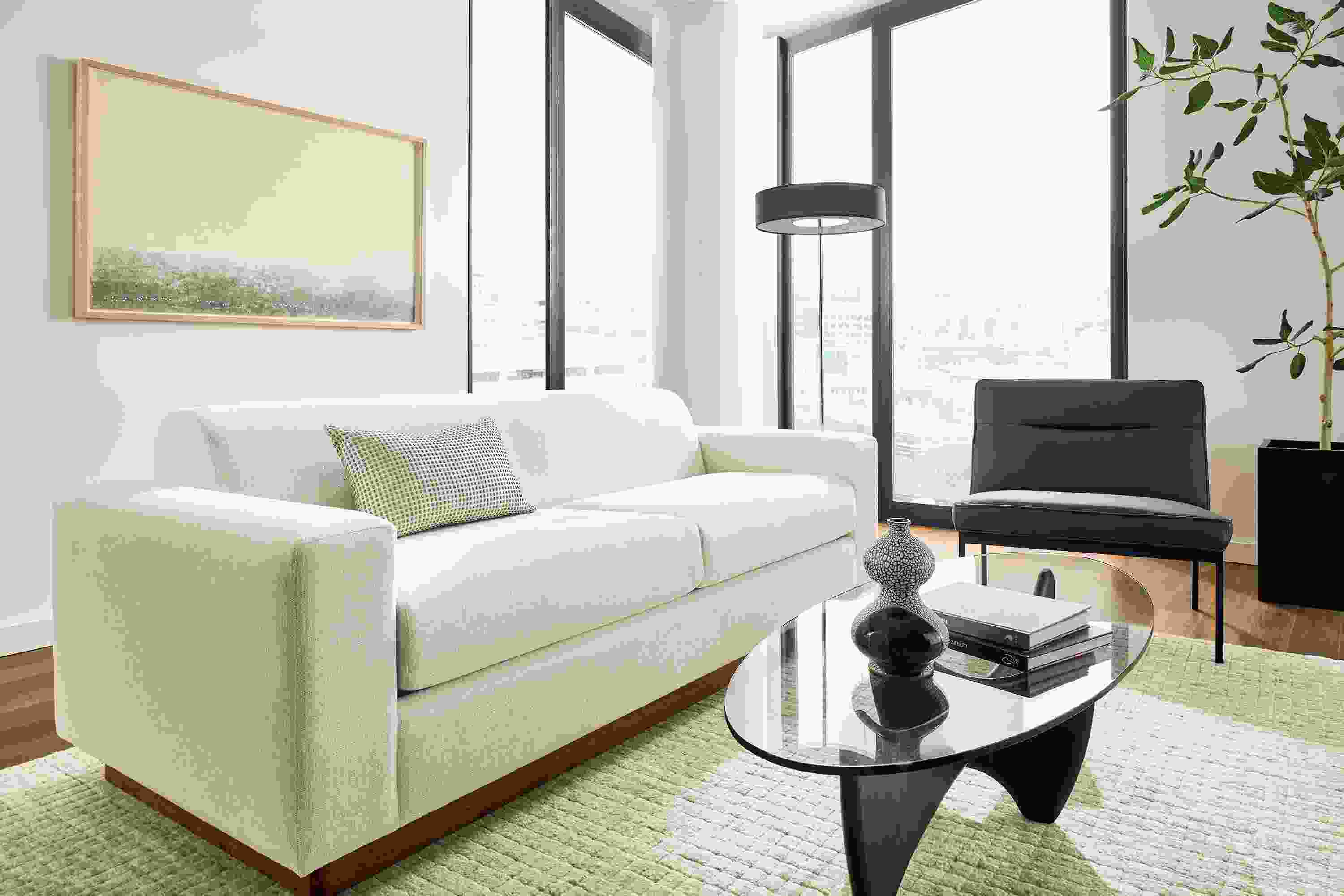 Living room with Harmon sofa in Tepic Ivory, Lisbon chair in Laino black leather and Safira rug in grey.