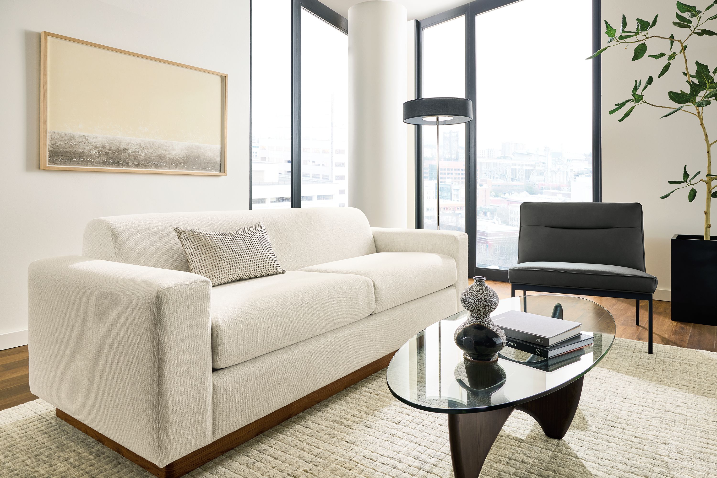 Living room with Harmon sofa in Tepic Ivory, Lisbon chair in Laino black leather and Safira rug in grey.