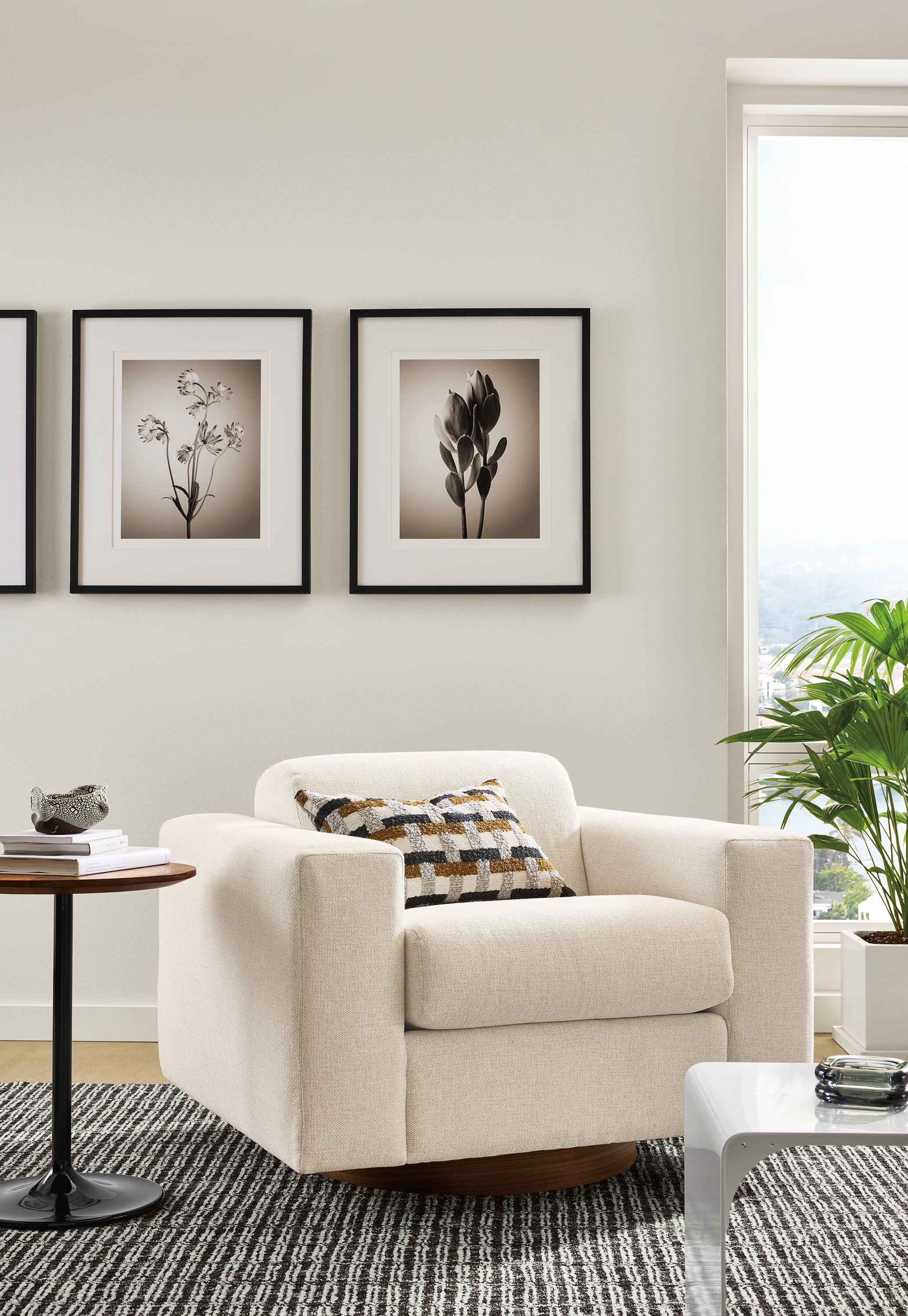 Living room with Harmon swivel chair in Tepic Ivory, Aria round table in walnut and onyx gloss and Nera rug.