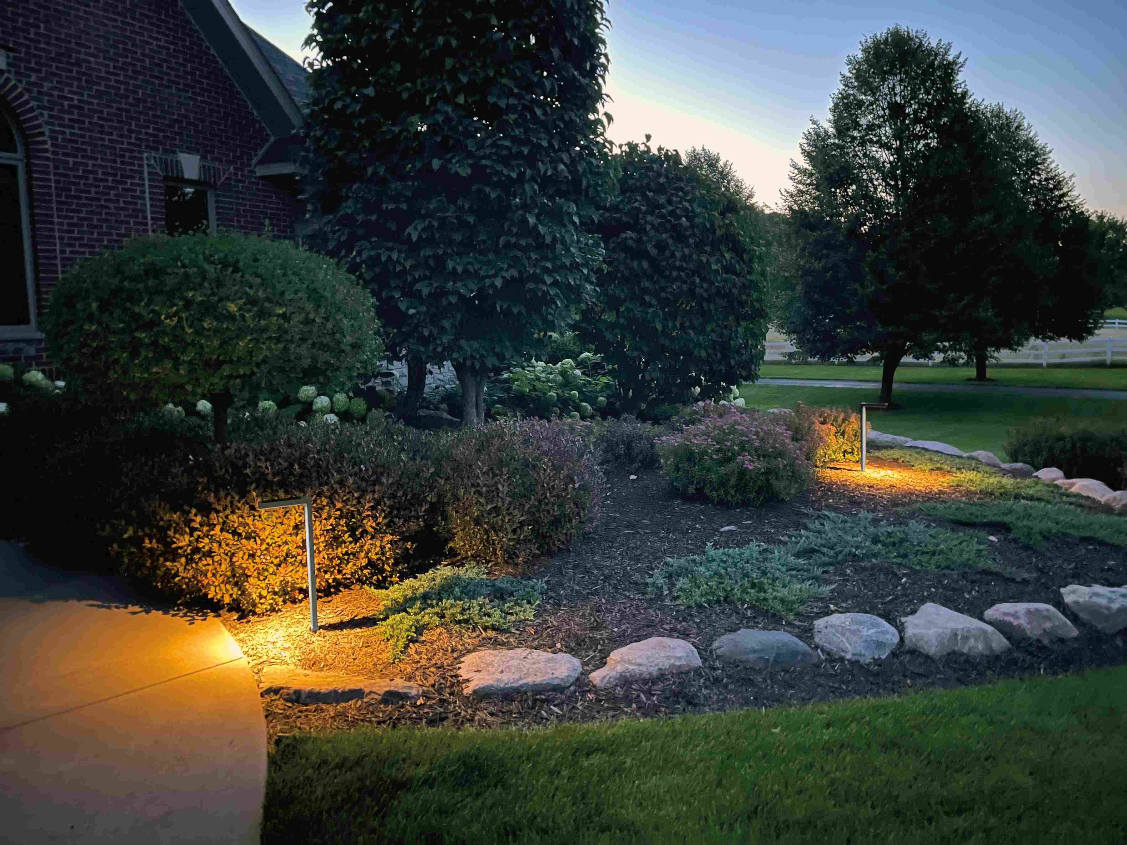 outdoor garden with Harvey Solar Light in Grey at dusk.