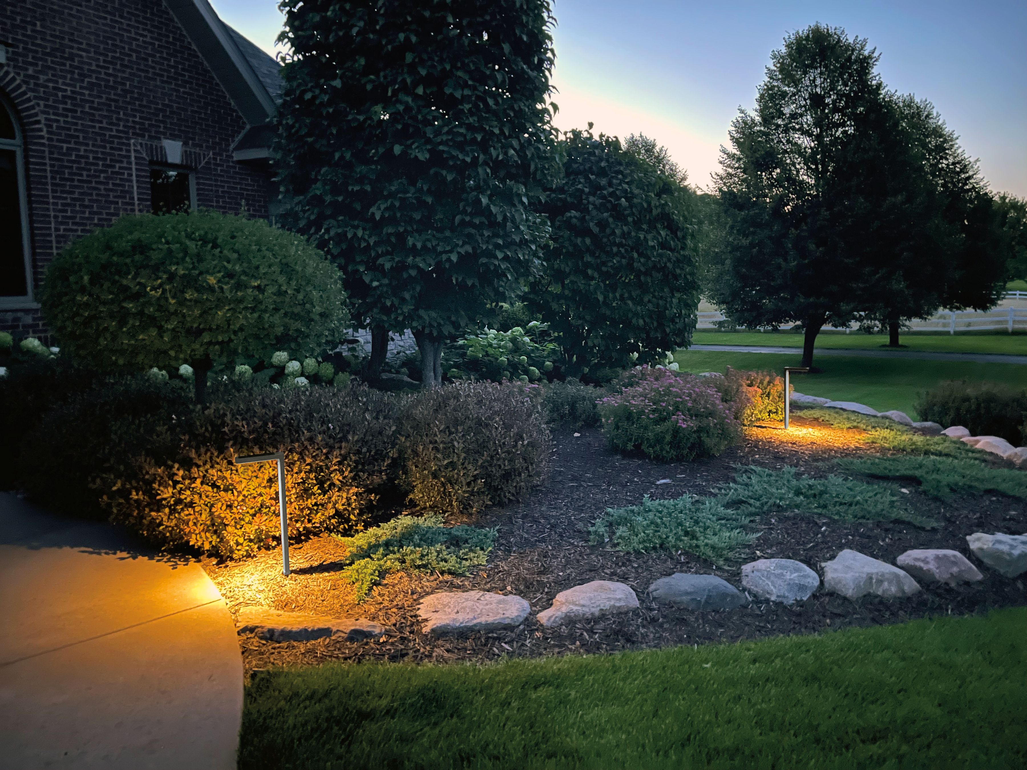 outdoor garden with Harvey Solar Light in Grey at dusk.