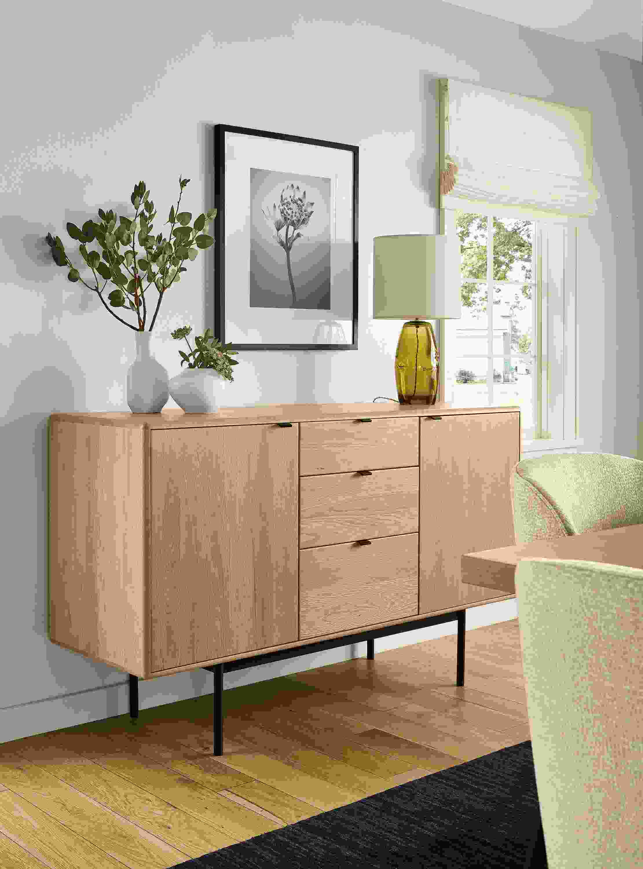Dining area with detail of Hensley 60-wide storage cabinet in rye on red oak, Grace table lamp in olive and Ripple vase in white.