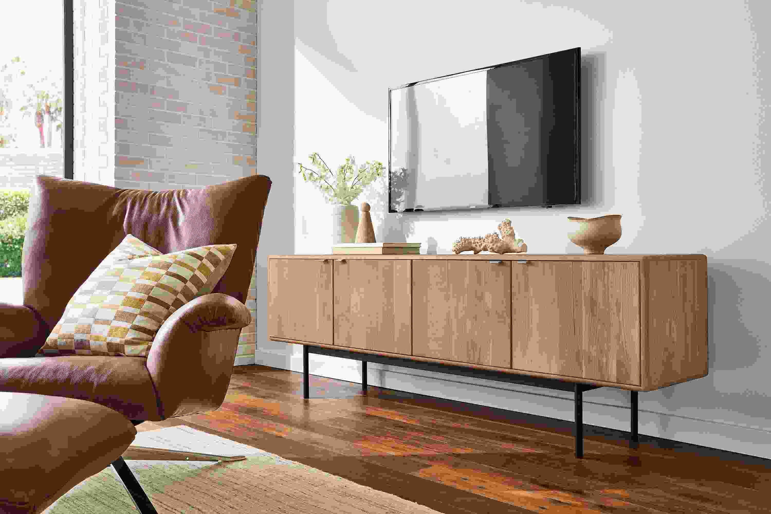 Living room with hensley media cabinet in rye on red oak and paris swivel chair in lecco cognac.